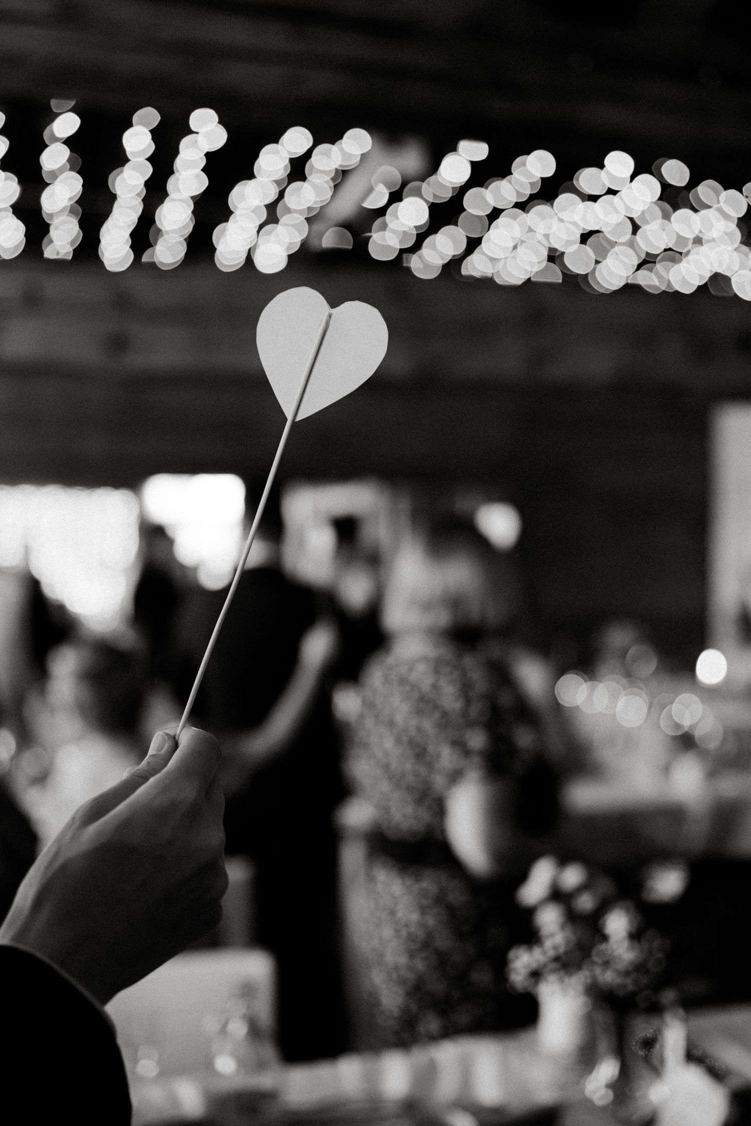 Black and white photo of heart-shaped decorations with bokeh lights in the background.