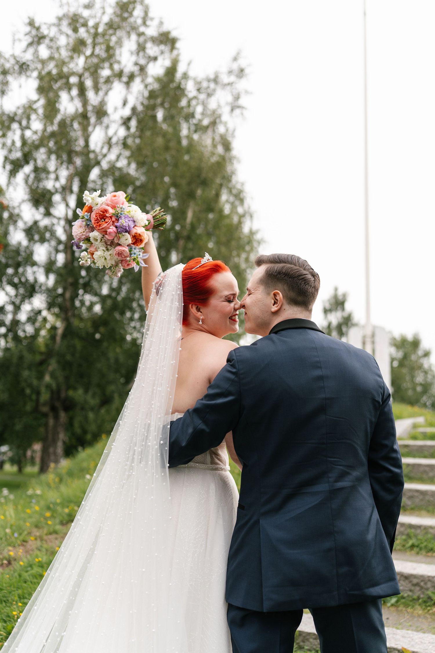 Wedding couple sharing an intimate moment on outdoor stone steps.
