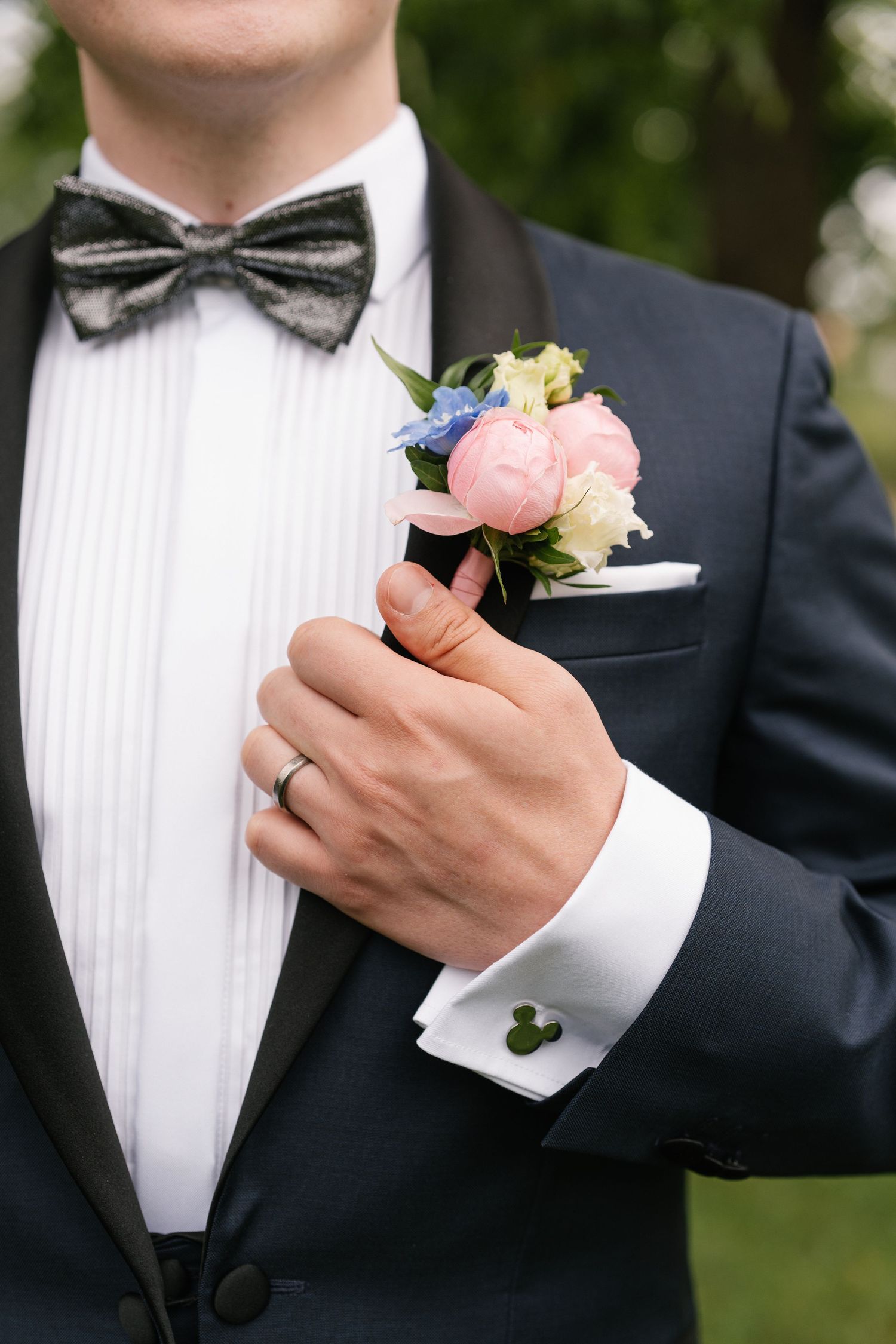 Close-up details of boutonnieres and formal attire at an elegant wedding.