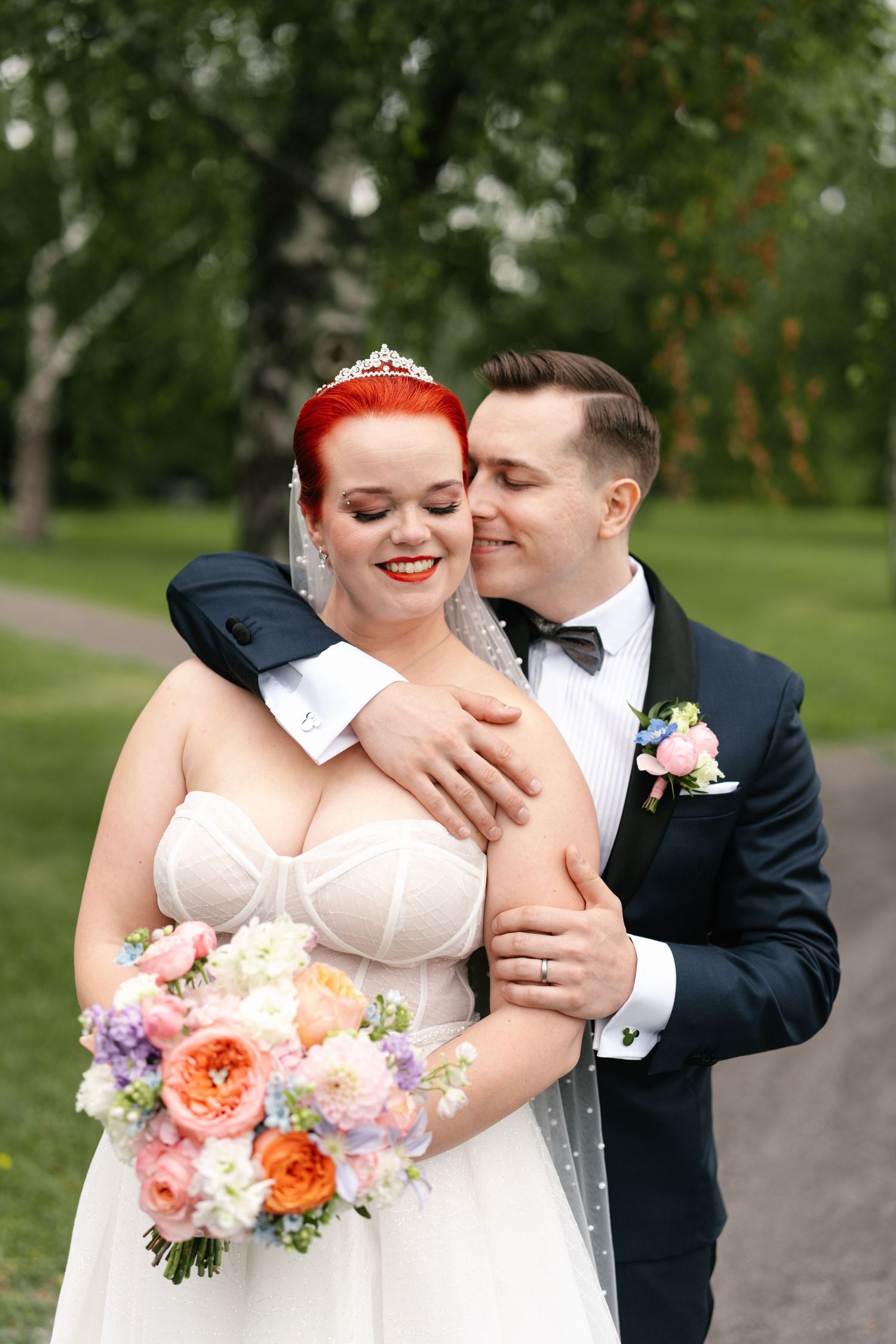 Romantic outdoor wedding portraits on garden path with birch trees in background.