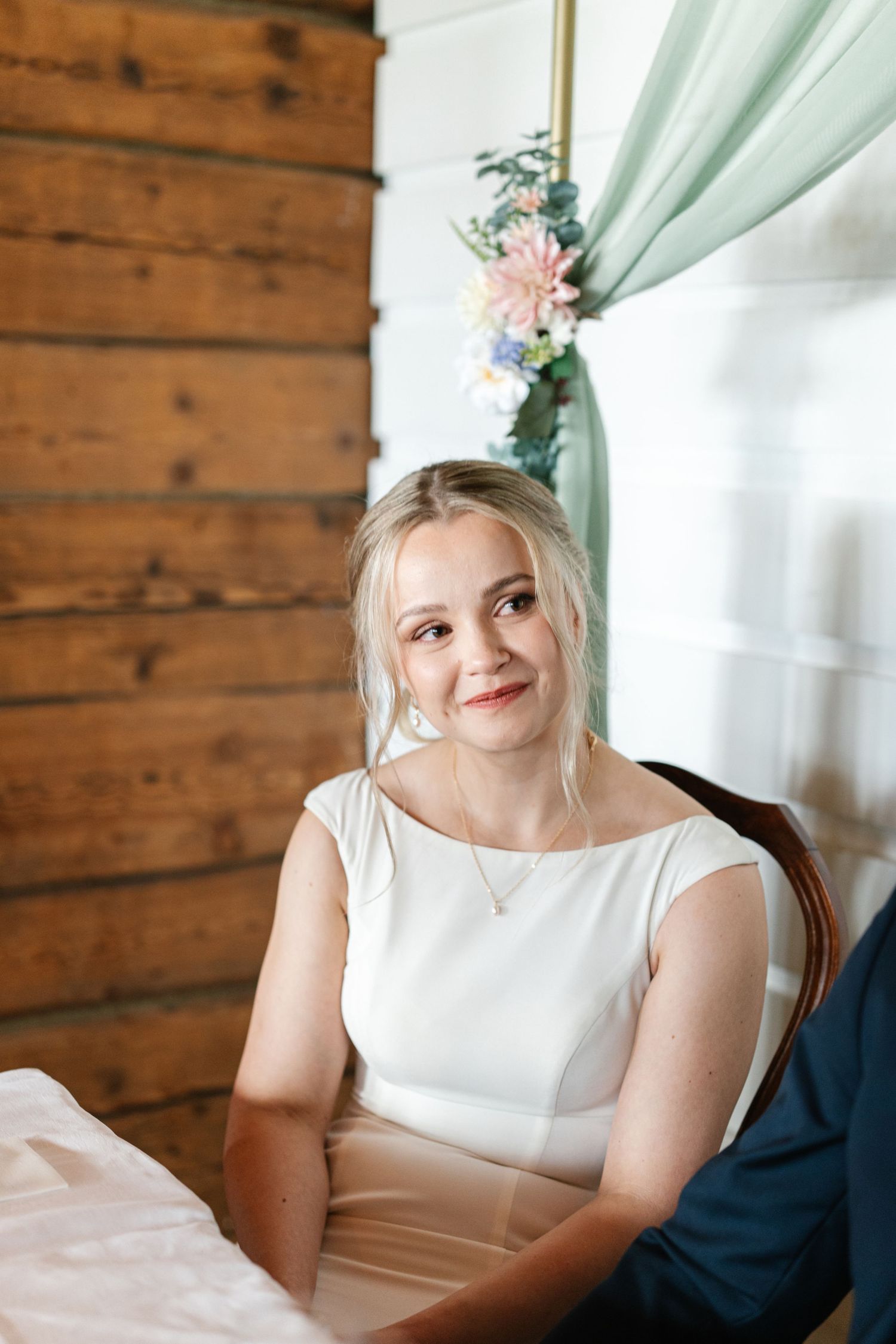 Elegant wedding reception in a rustic wooden room with mint green decor and floral accents.