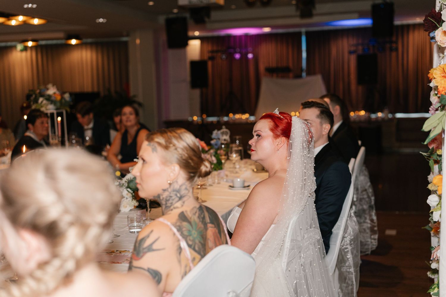 Wedding reception venue with purple mood lighting and decorated tables.