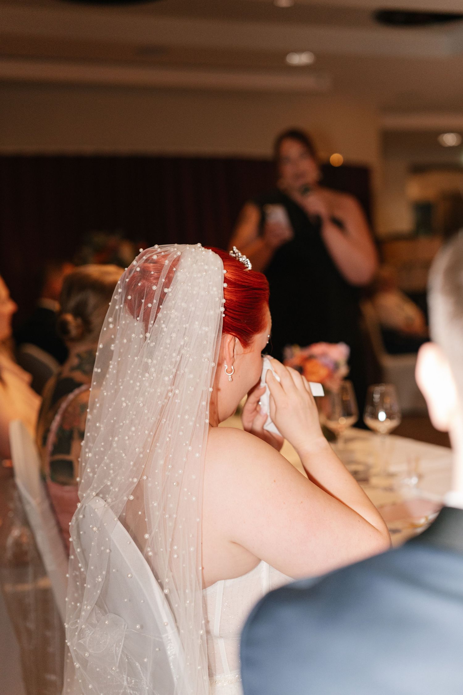 Wedding guests enjoying drinks and conversation at an indoor reception.