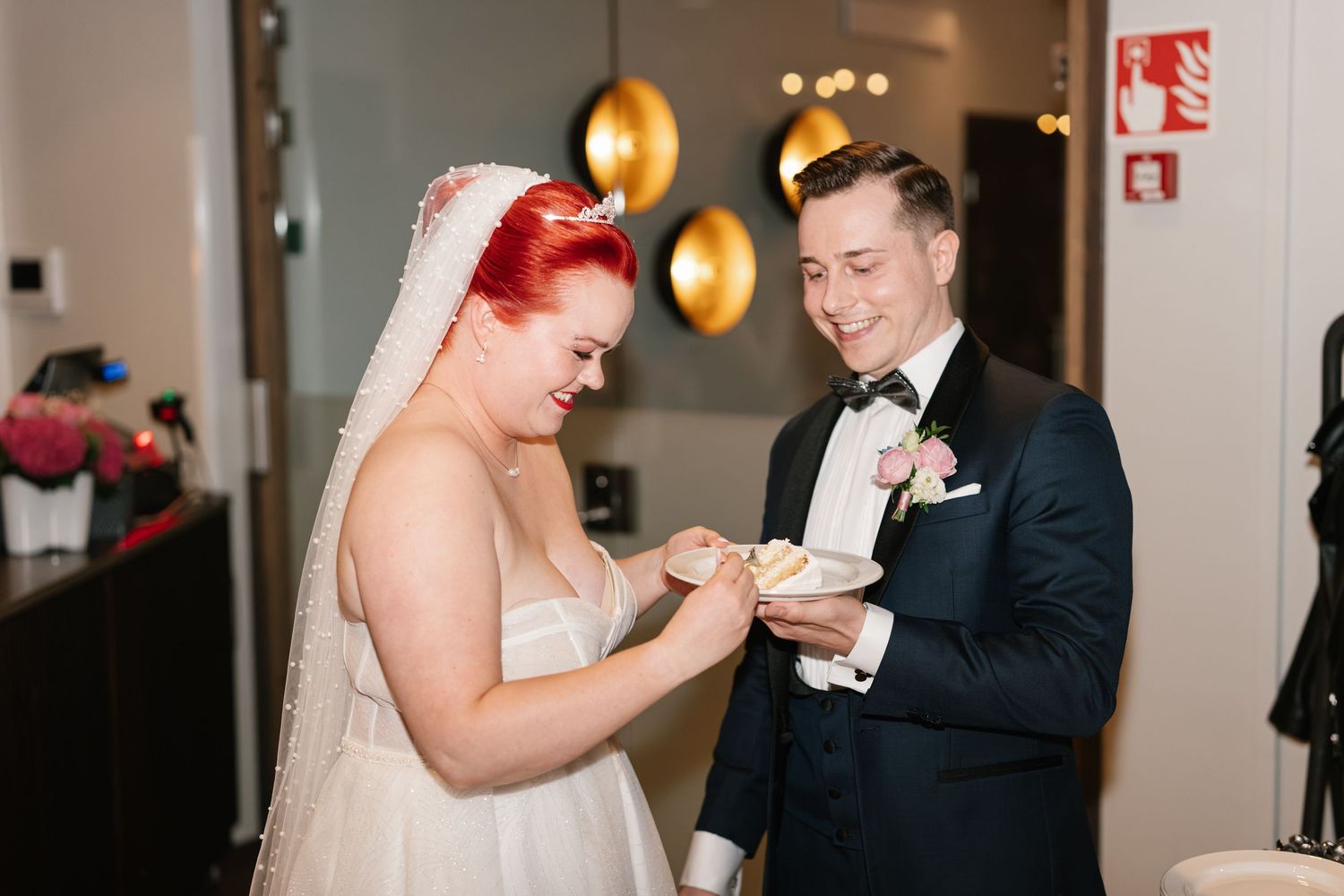 Newlyweds sharing cake during traditional wedding cake cutting ceremony.