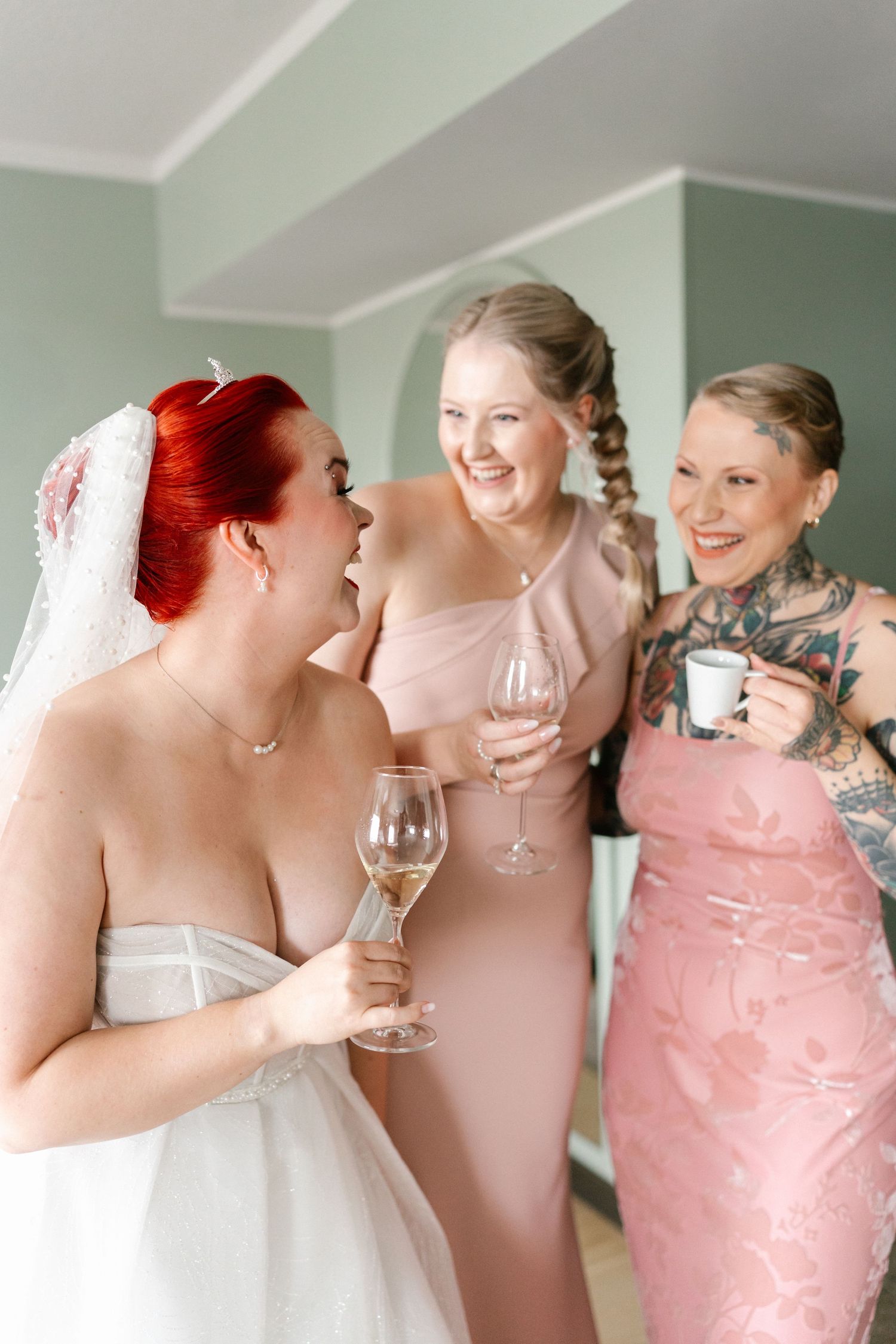 Wedding party members in pink dresses celebrate with champagne glasses.