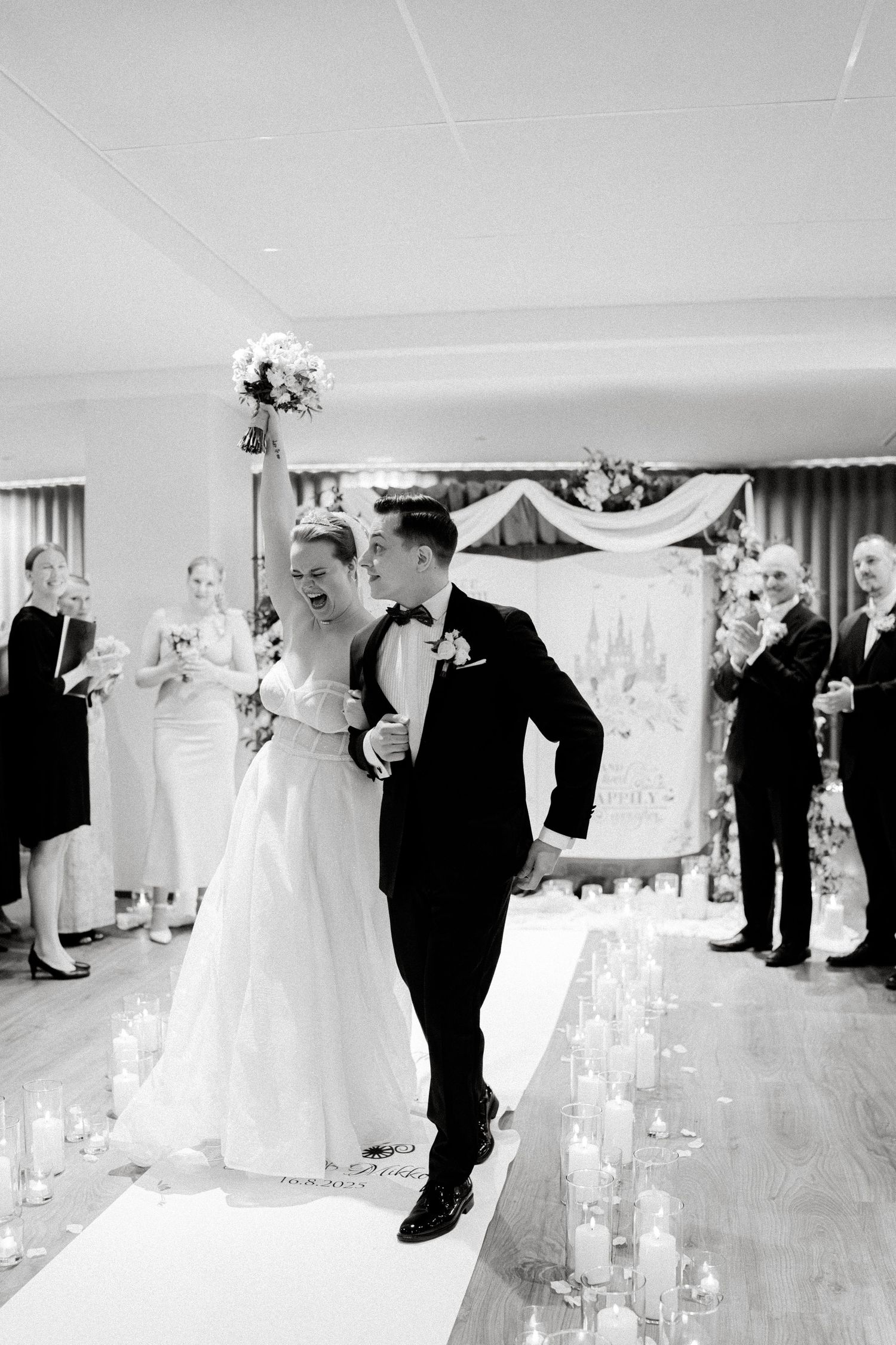 A couple shares an emotional moment during their wedding ceremony in a beautifully decorated white room.