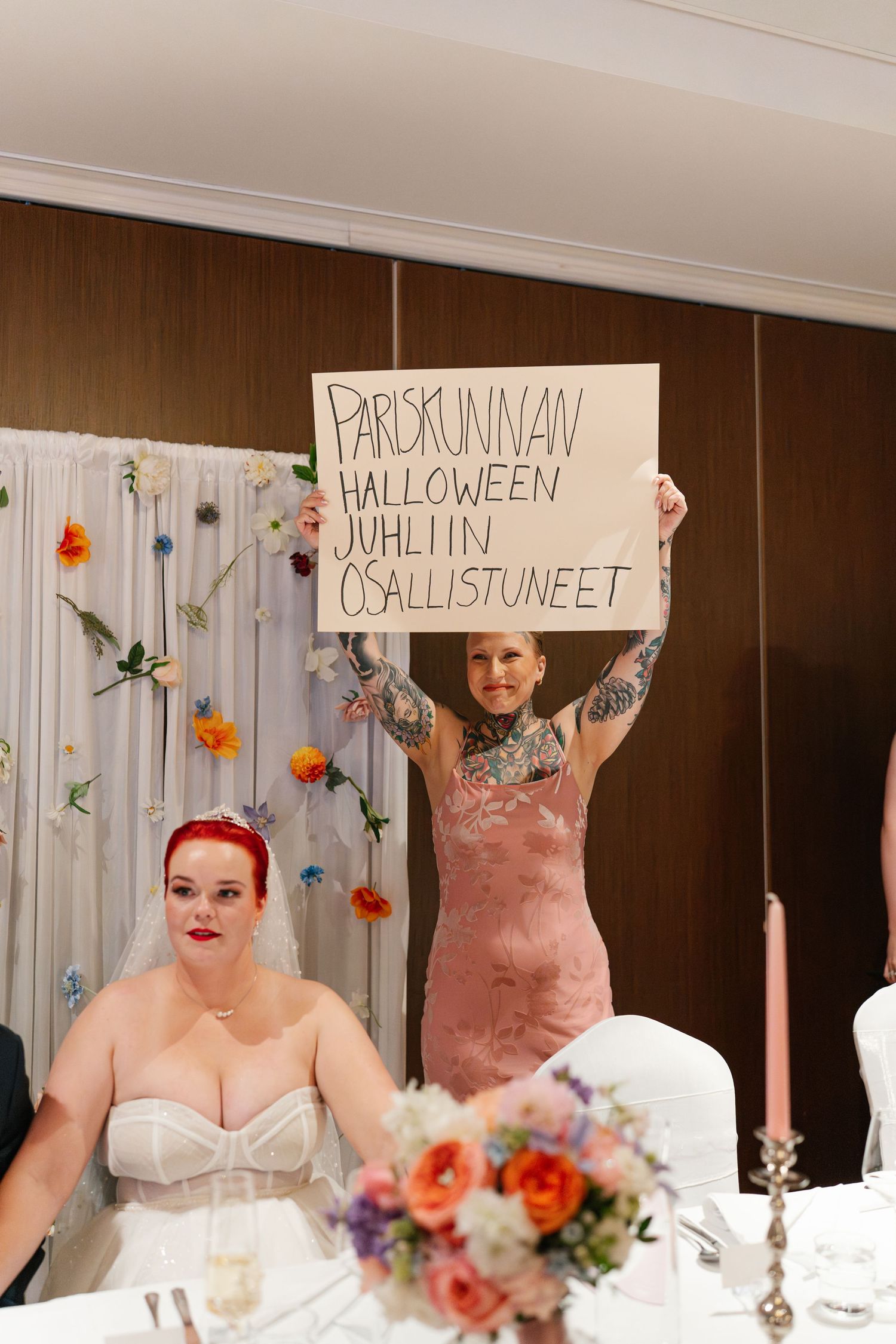 Wedding couple holds up fun handwritten signs during their reception celebration.
