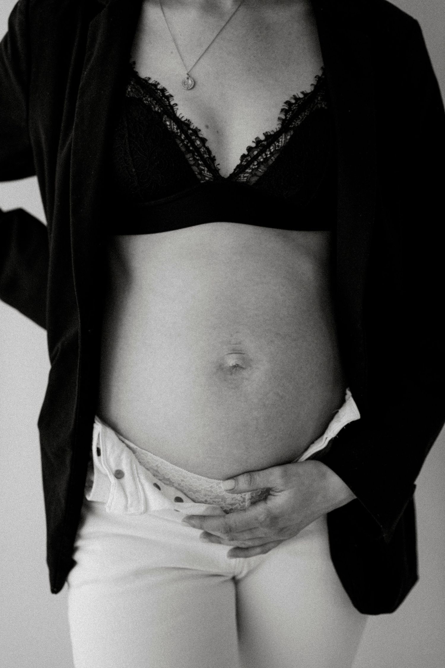 Black and white artistic maternity photos showing pregnant belly with black top.