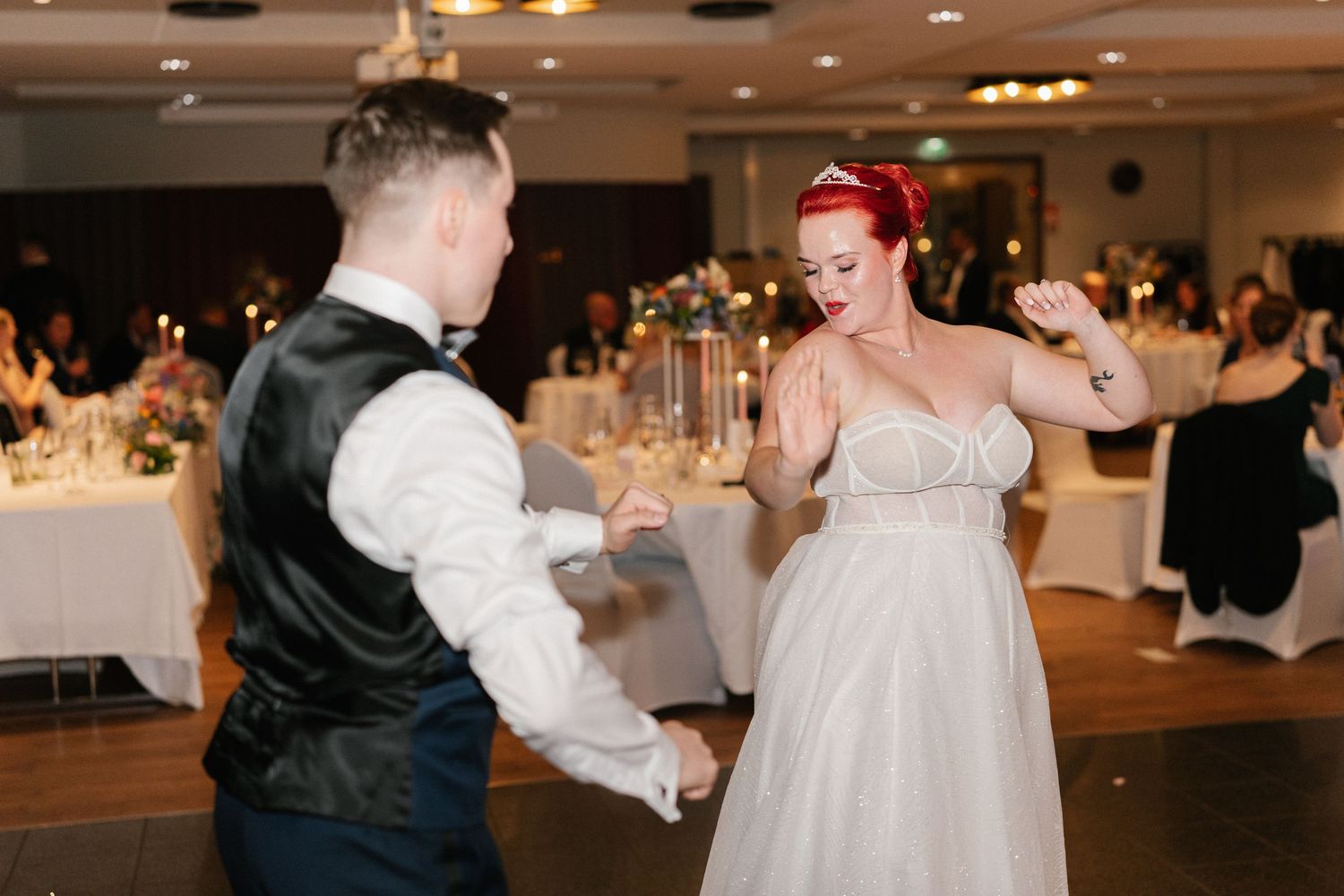 Wedding guests dance and celebrate on the reception dance floor.