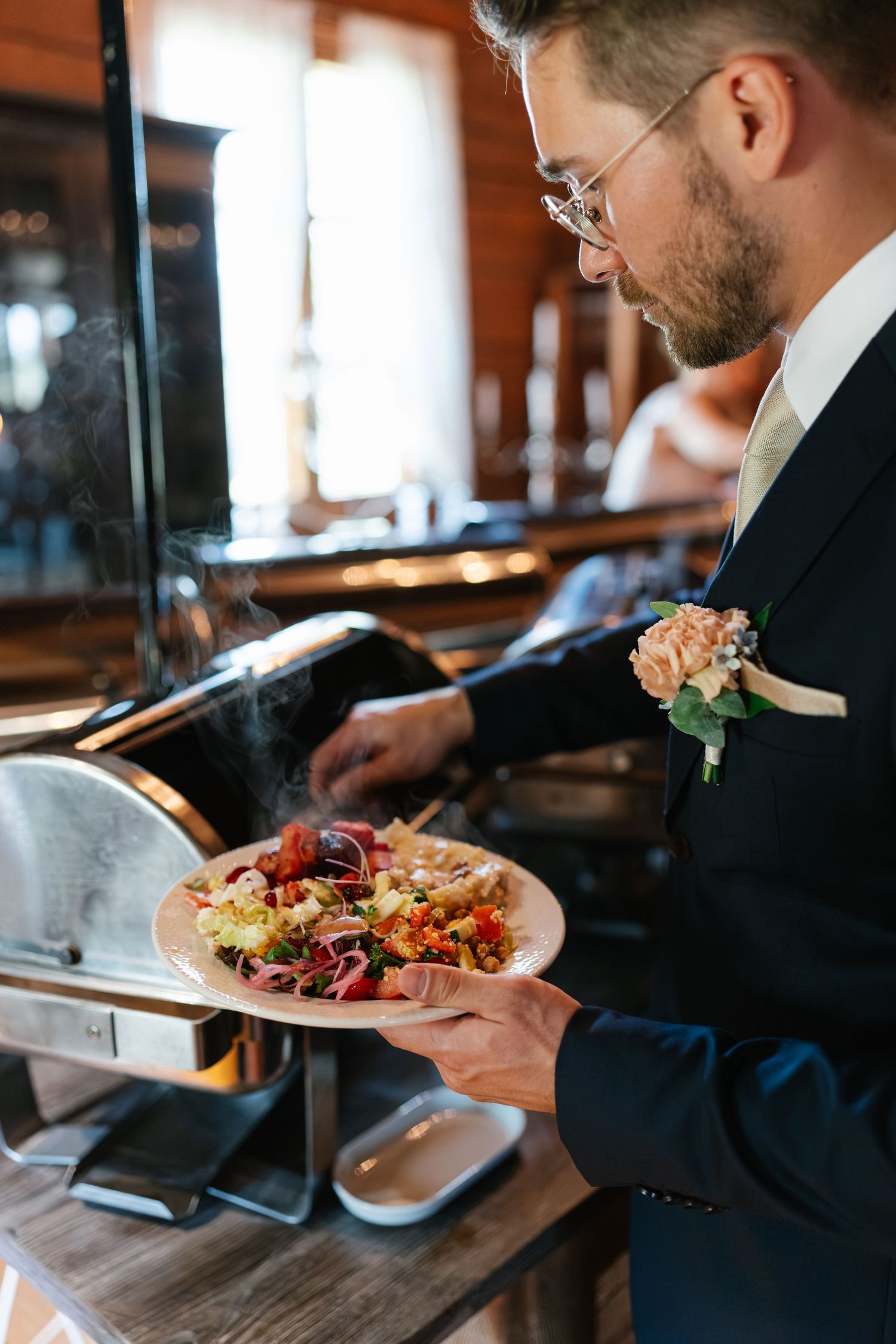 Wedding guests enjoying plated meals at an elegant rustic reception.
