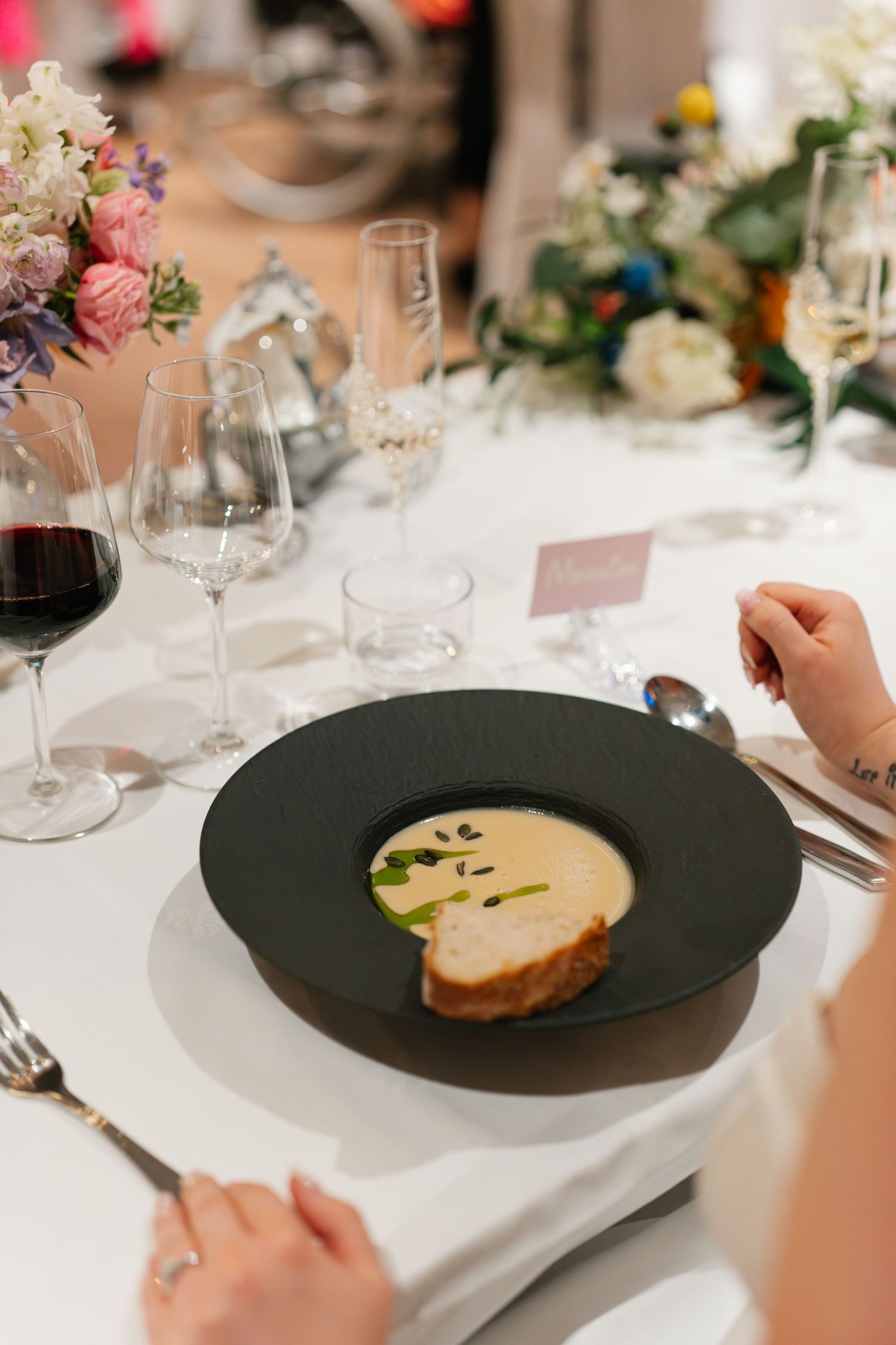 Elegant plated dishes being served at a formal wedding reception dinner.