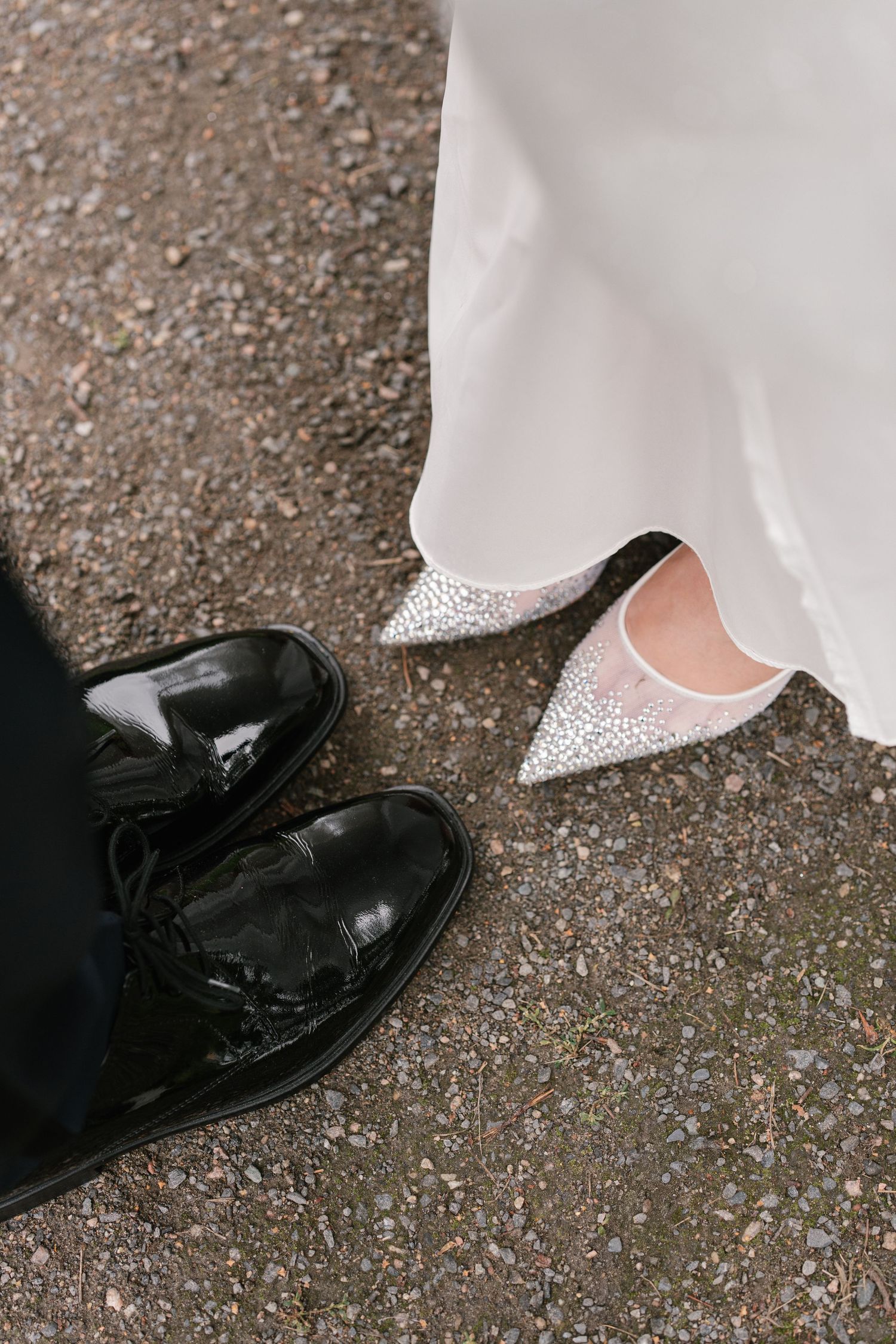 Wedding shoes detail shot showing contrast between formal and bridal footwear.
