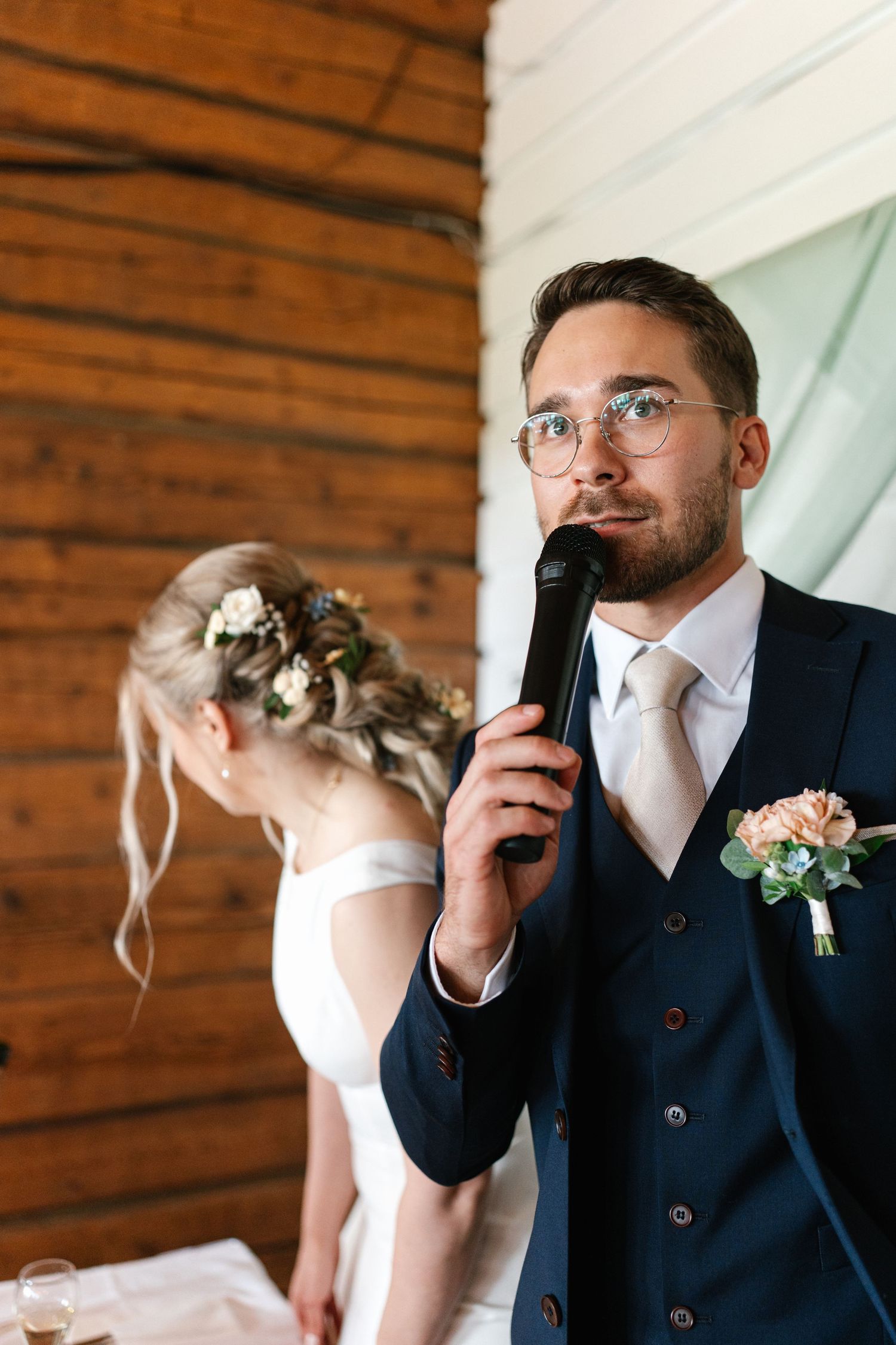 Wedding couple shares emotional first look moment in rustic wooden interior setting.