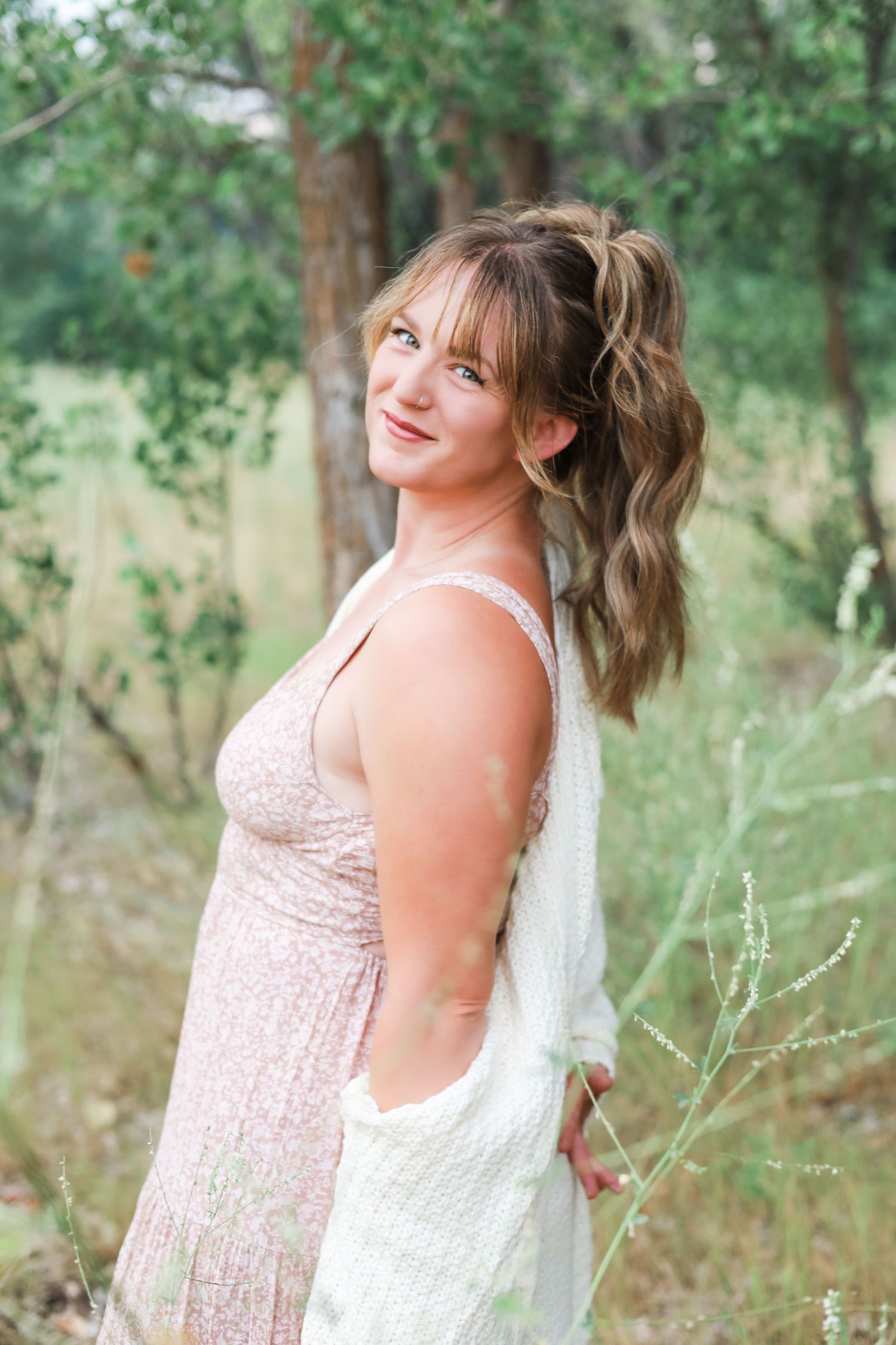 Portrait session in a natural outdoor setting with soft lighting and greenery.