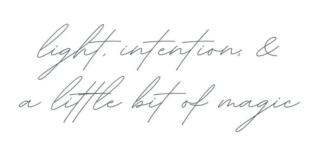 Handwritten cursive text in gray ink reads 'light intentions & a little bit of magic' on white background.