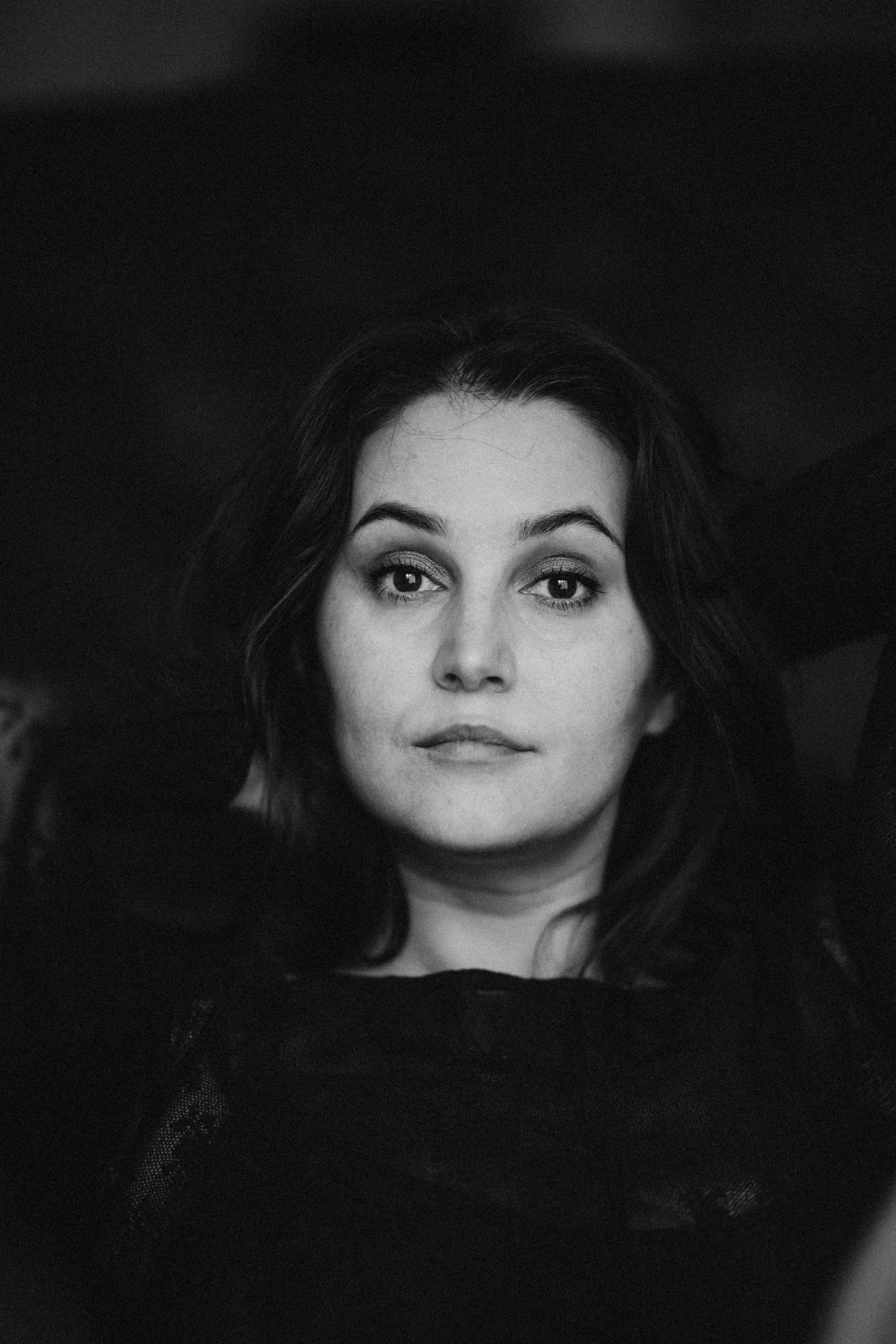 the photo of a woman looking into the camera in a black and white portrait