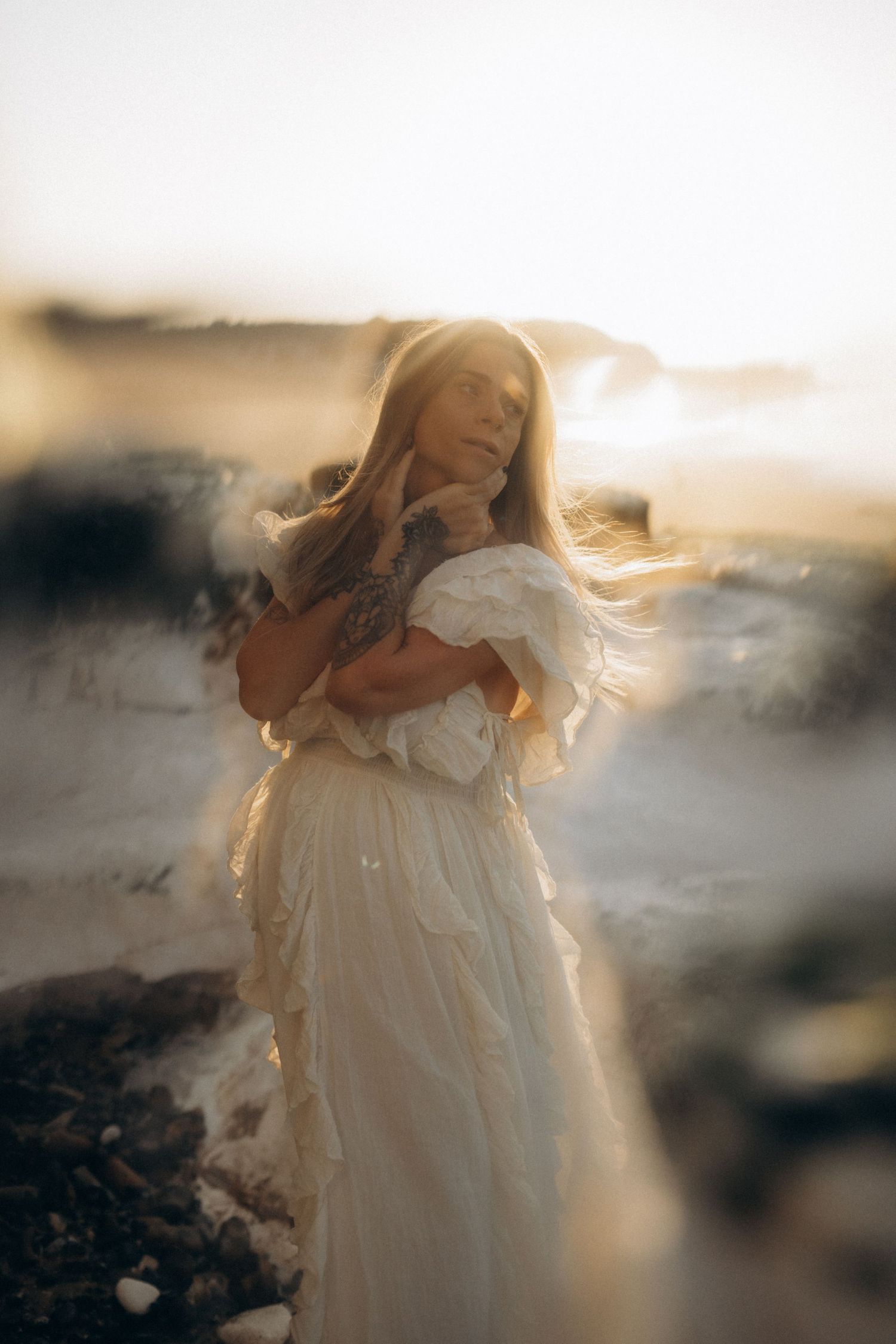 a pregnant woman standing on Botany Bay beach at sunset