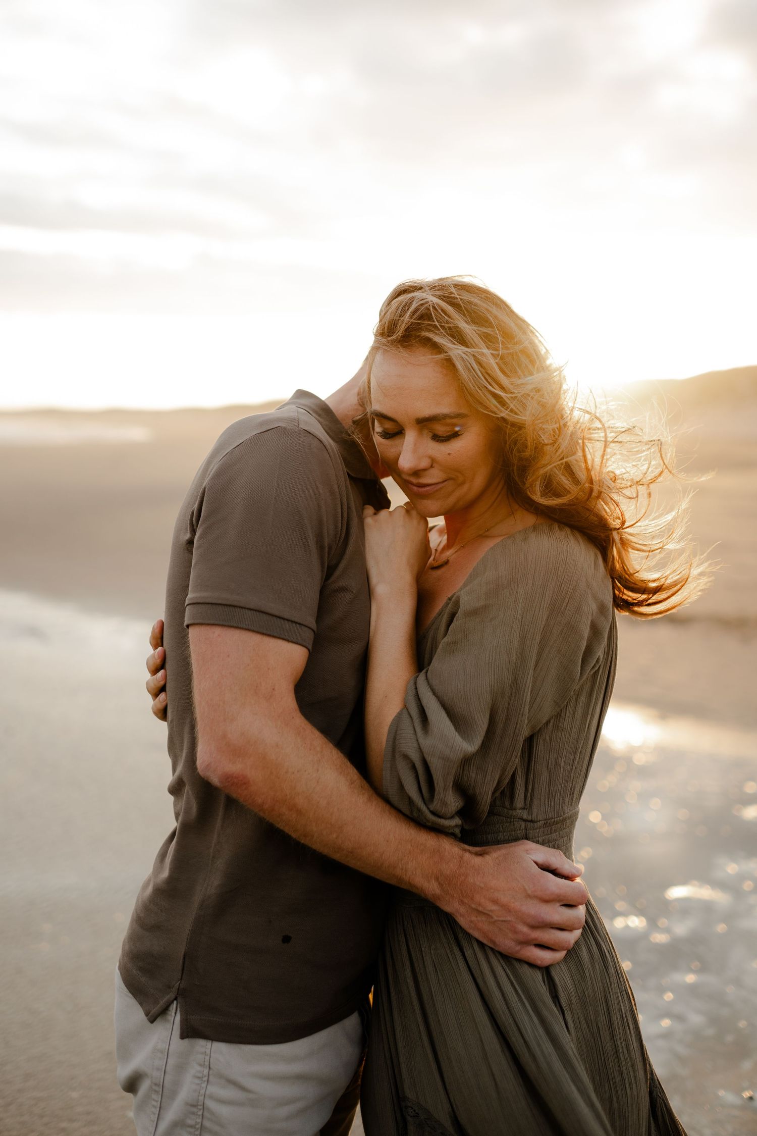 a couple embracing at sunset on the beach during a photo session in Kent