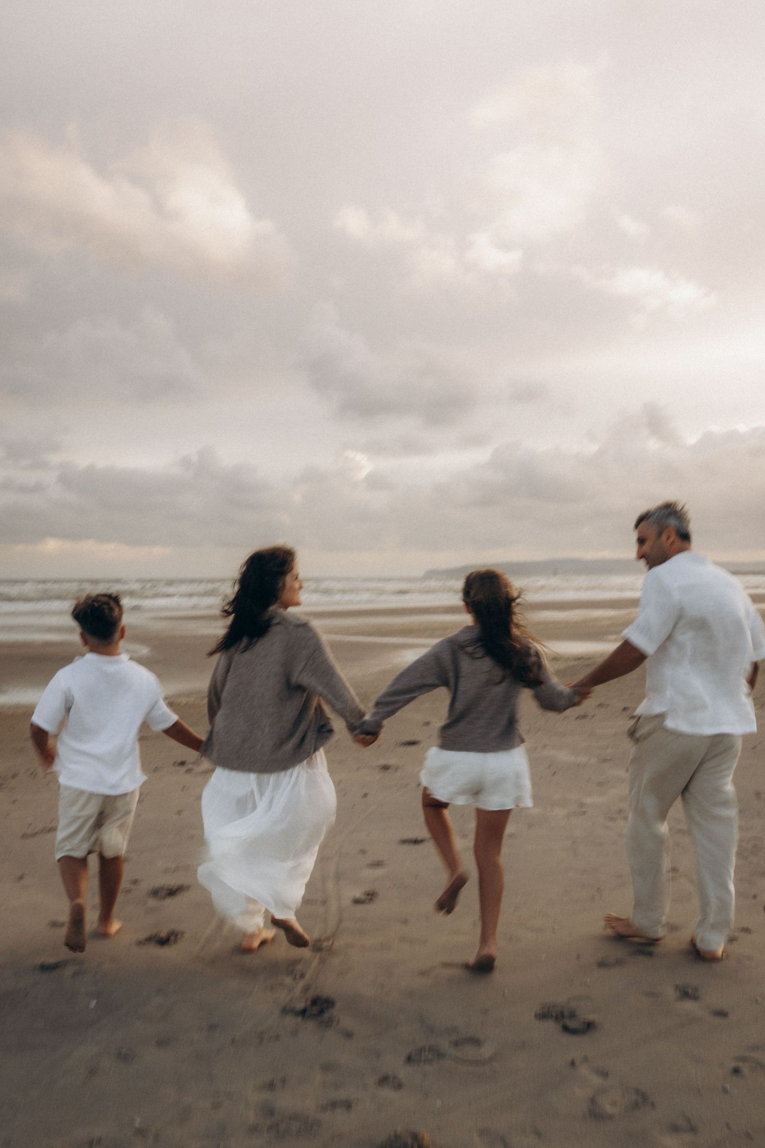 a family of four running in a poetic, out of focus shot, kent family photographer
