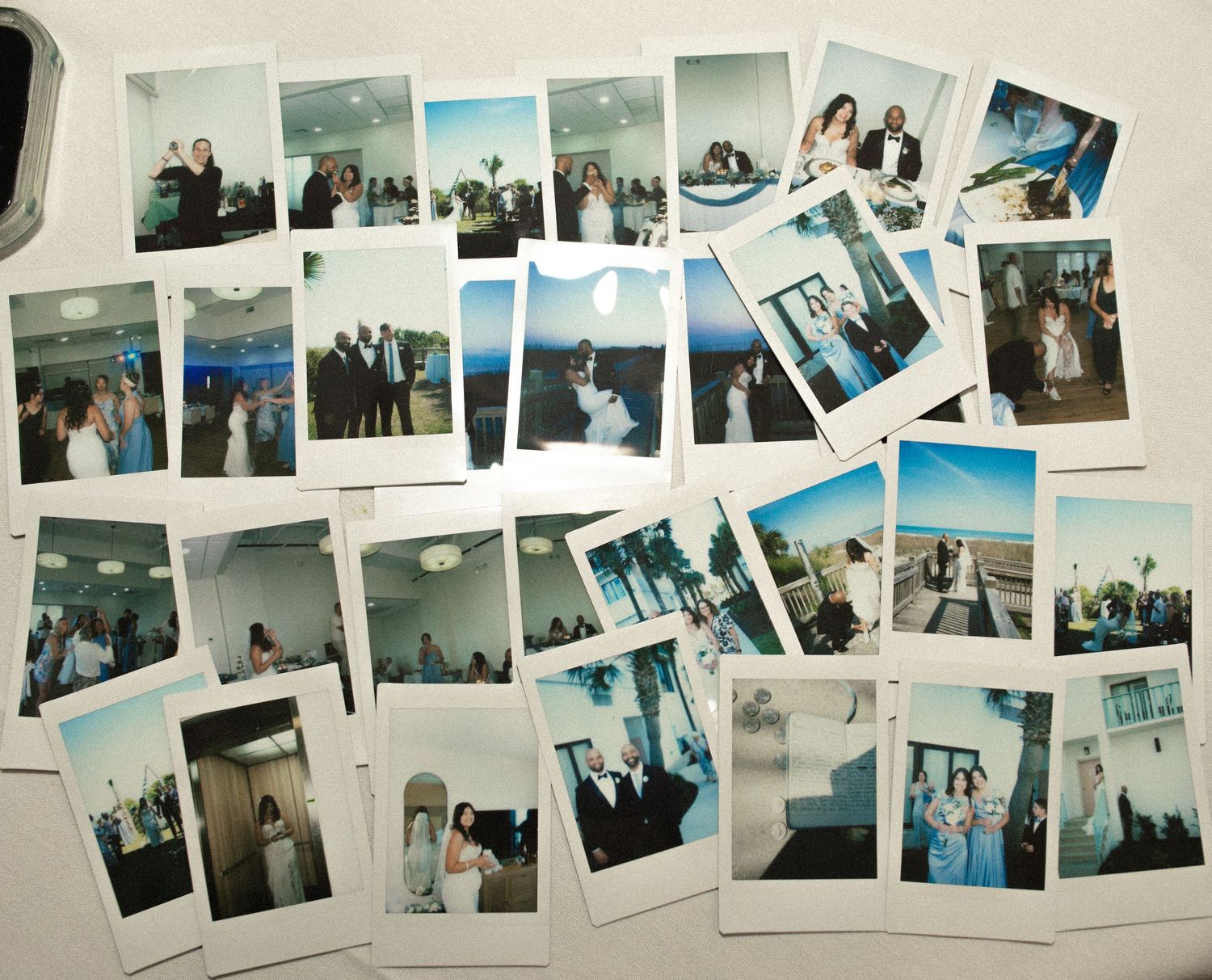 A collection of Polaroid photos spread out showing wedding moments with couples and guests in formal attire.