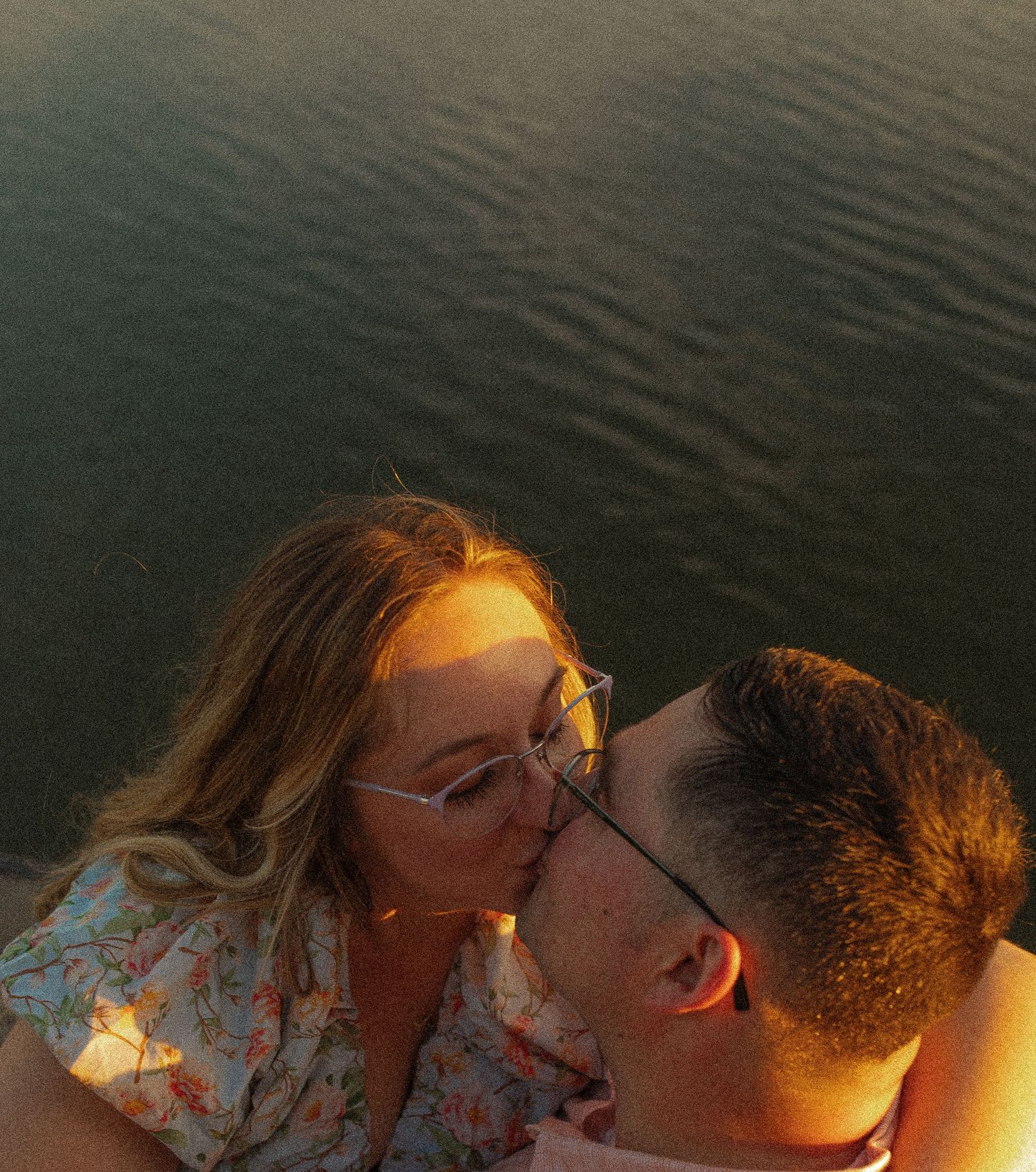 An intimate moment captured during sunset by the water.
