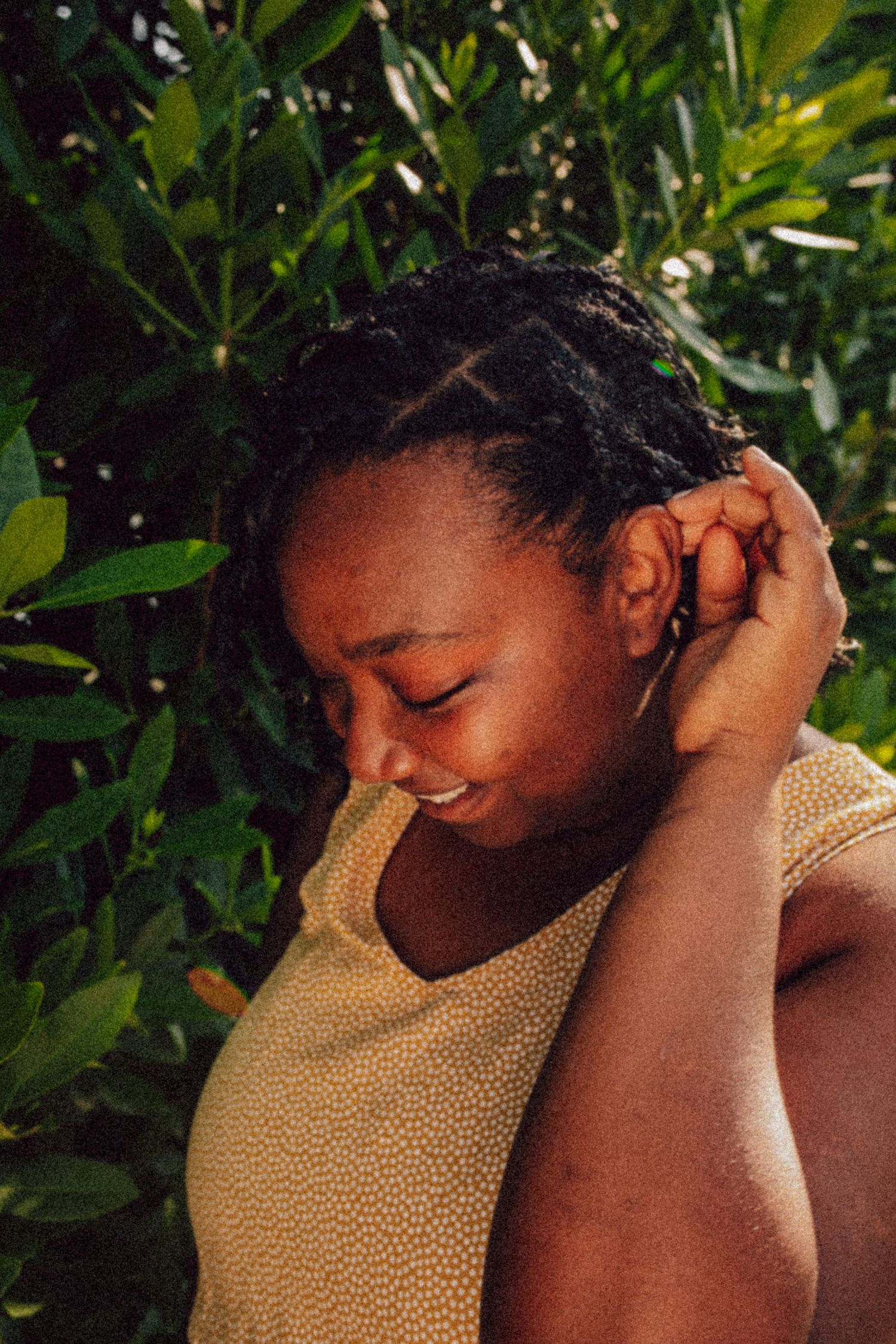Person creating a dynamic sequence of emotional expressions with natural foliage backdrop.