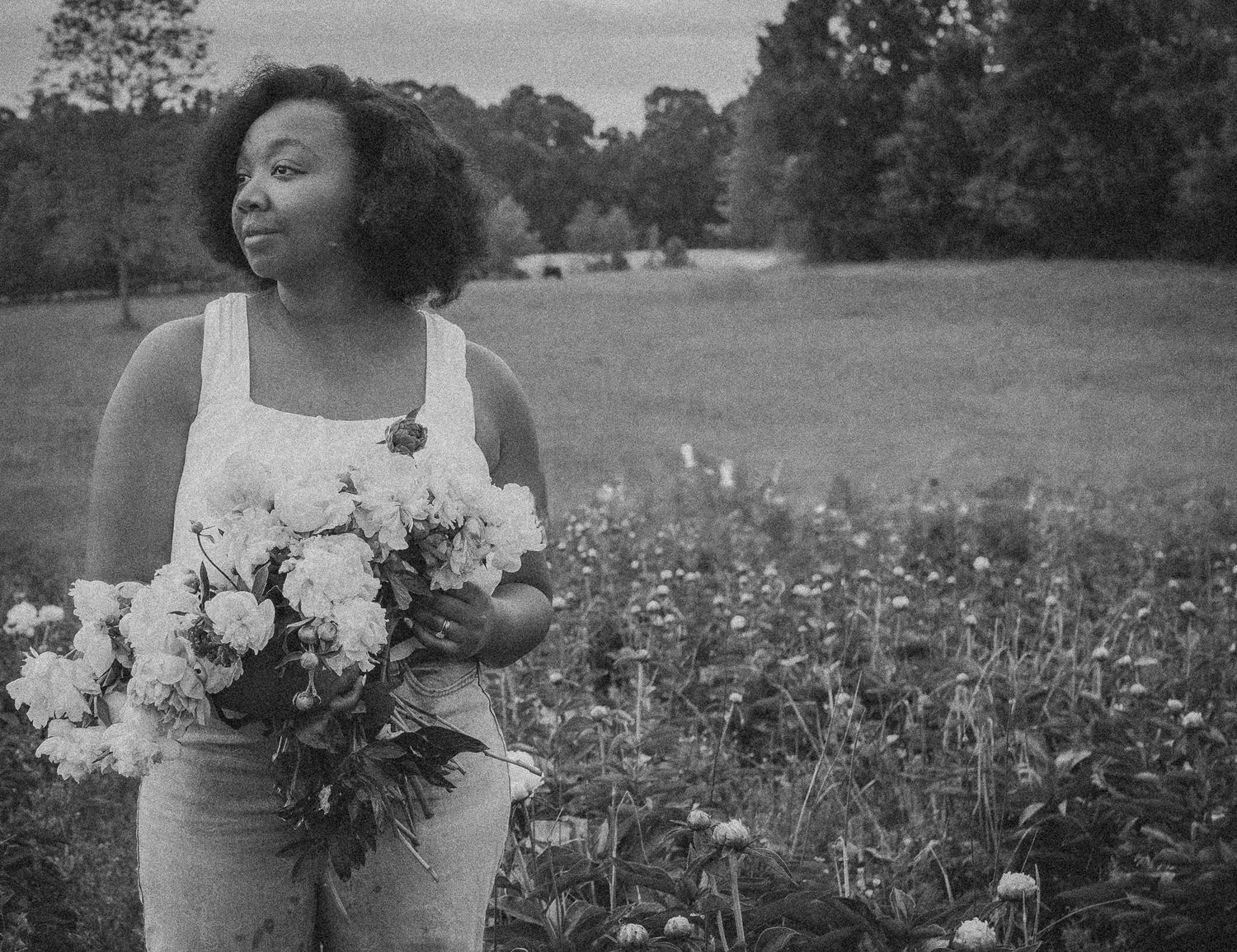 Black and white photo of a romantic outdoor wedding photoshoot in a blooming flower field.