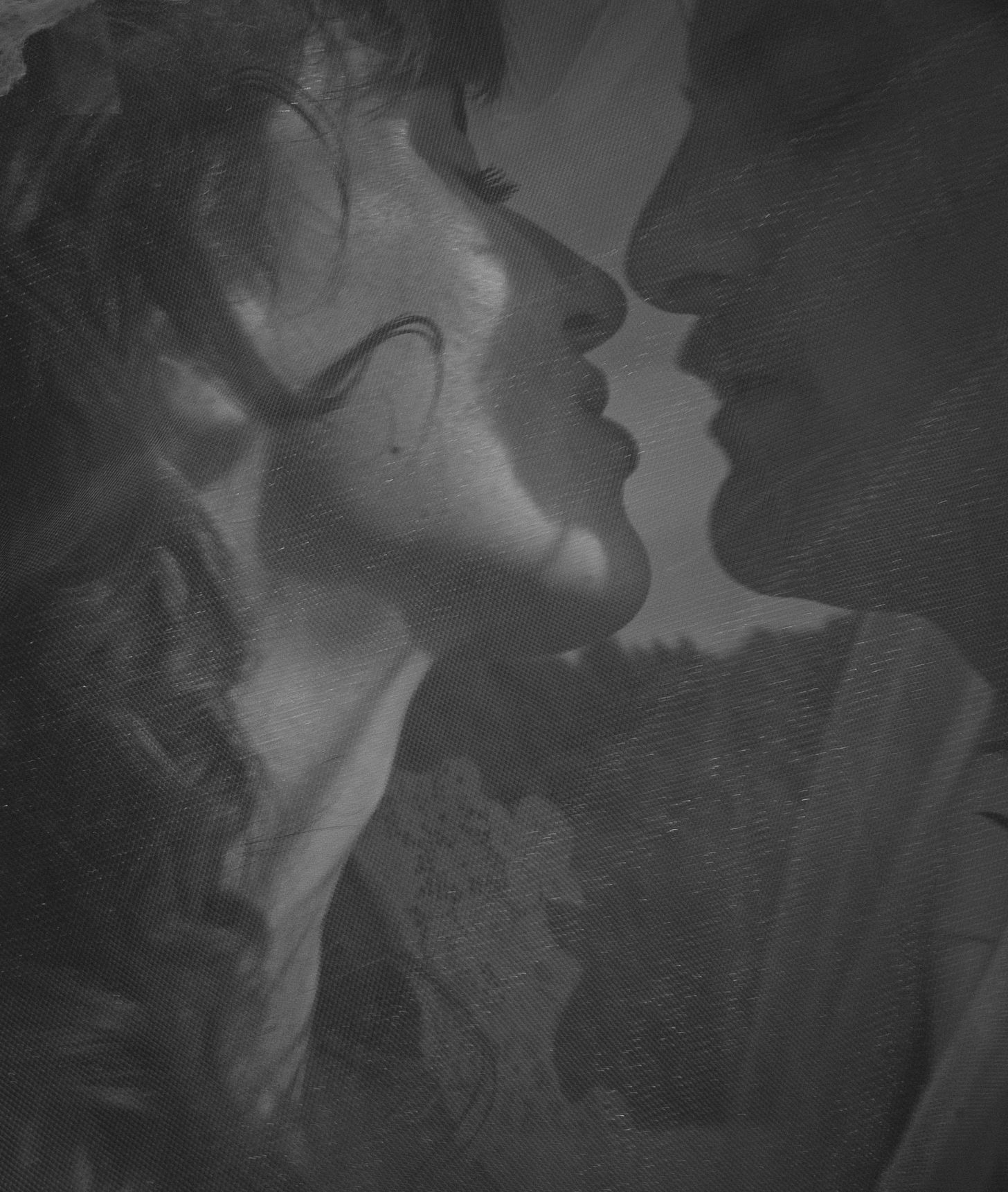 Black and white romantic close-up of a couple about to kiss, captured in a classic vintage photography style.