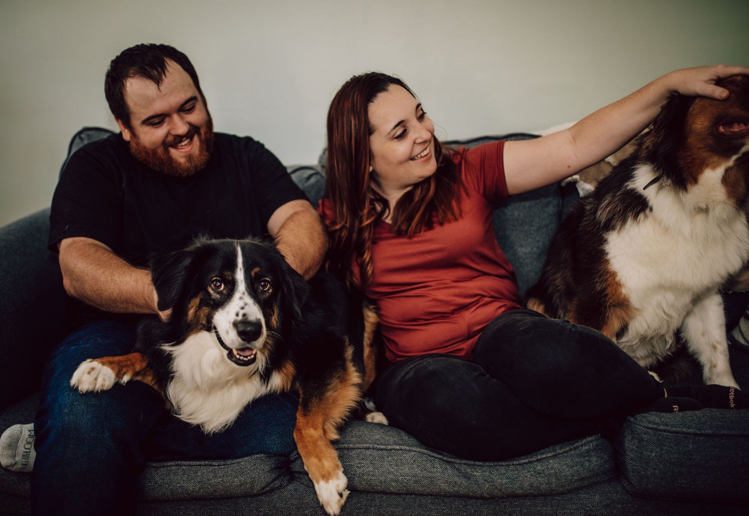 Relaxed group lounging on couch with Australian Shepherd dog.