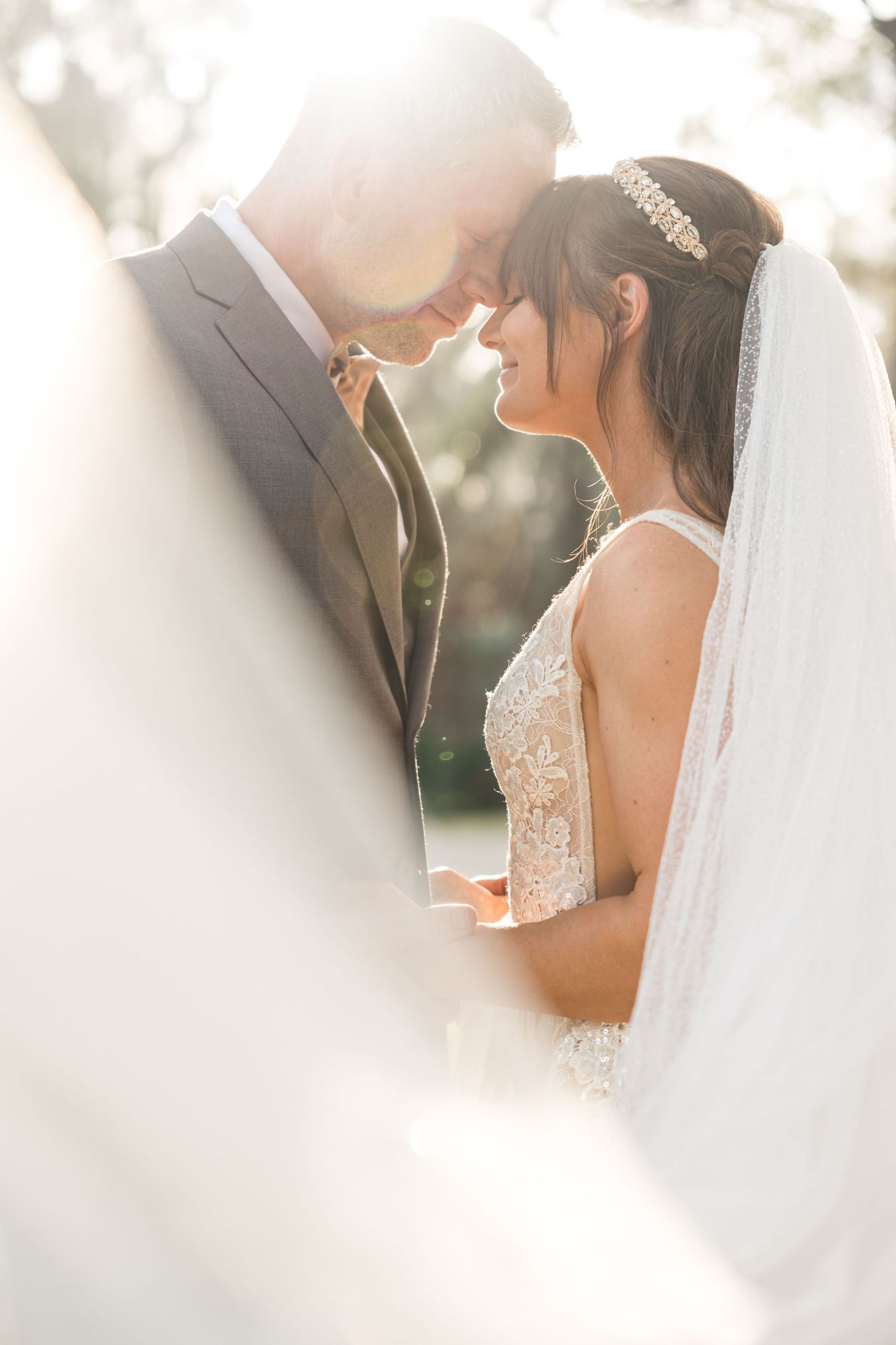 Ethereal wedding portraits with soft backlighting and flowing veil.