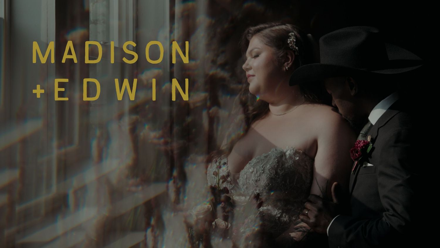 Madison and Edwin wedding photo featuring bride in elegant gown gazing through window with groom in dark suit behind her.