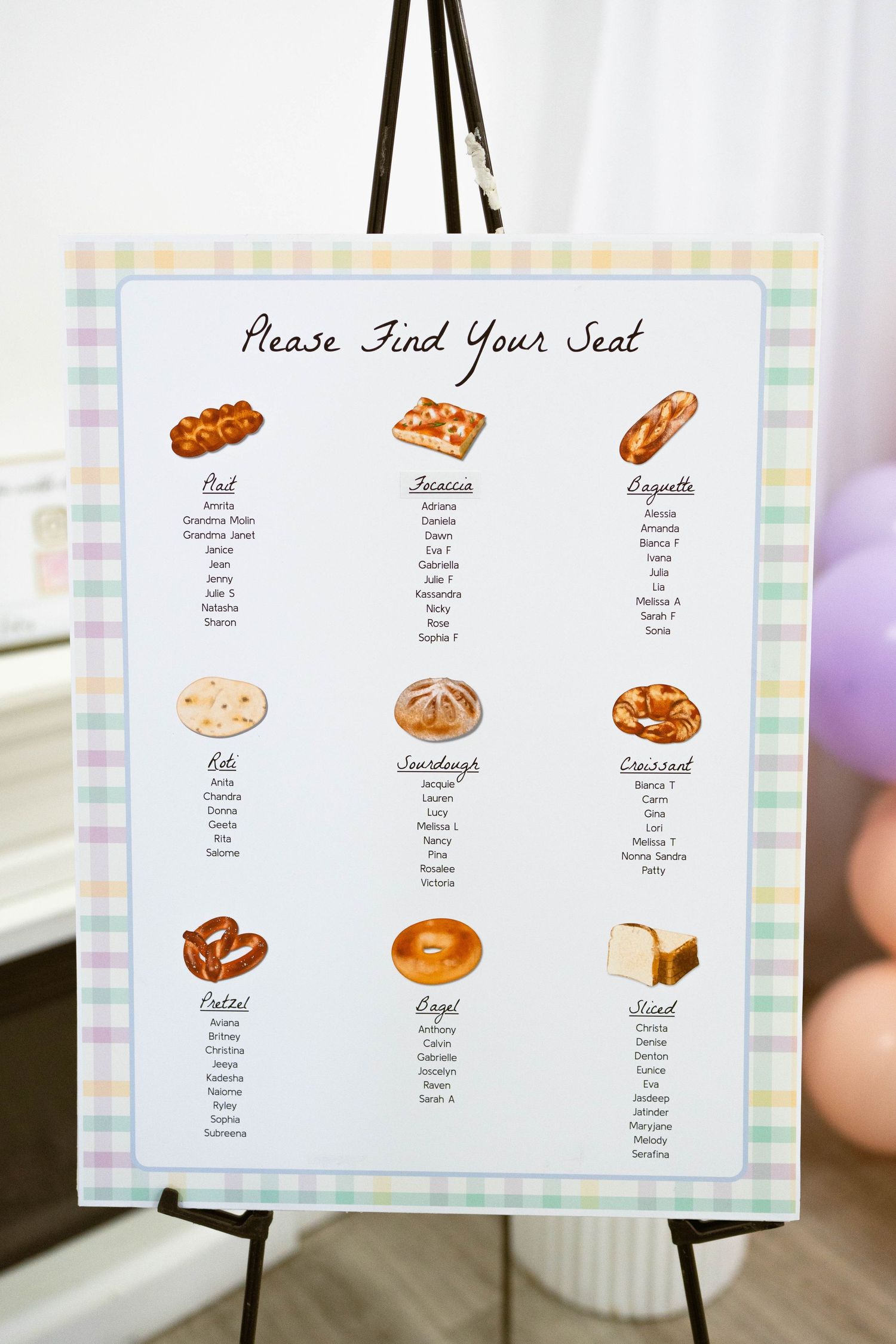 Pastel gingham seating chart titled Please Find Your Seat with bread illustrations like croissant, bagel and sourdough for each table.