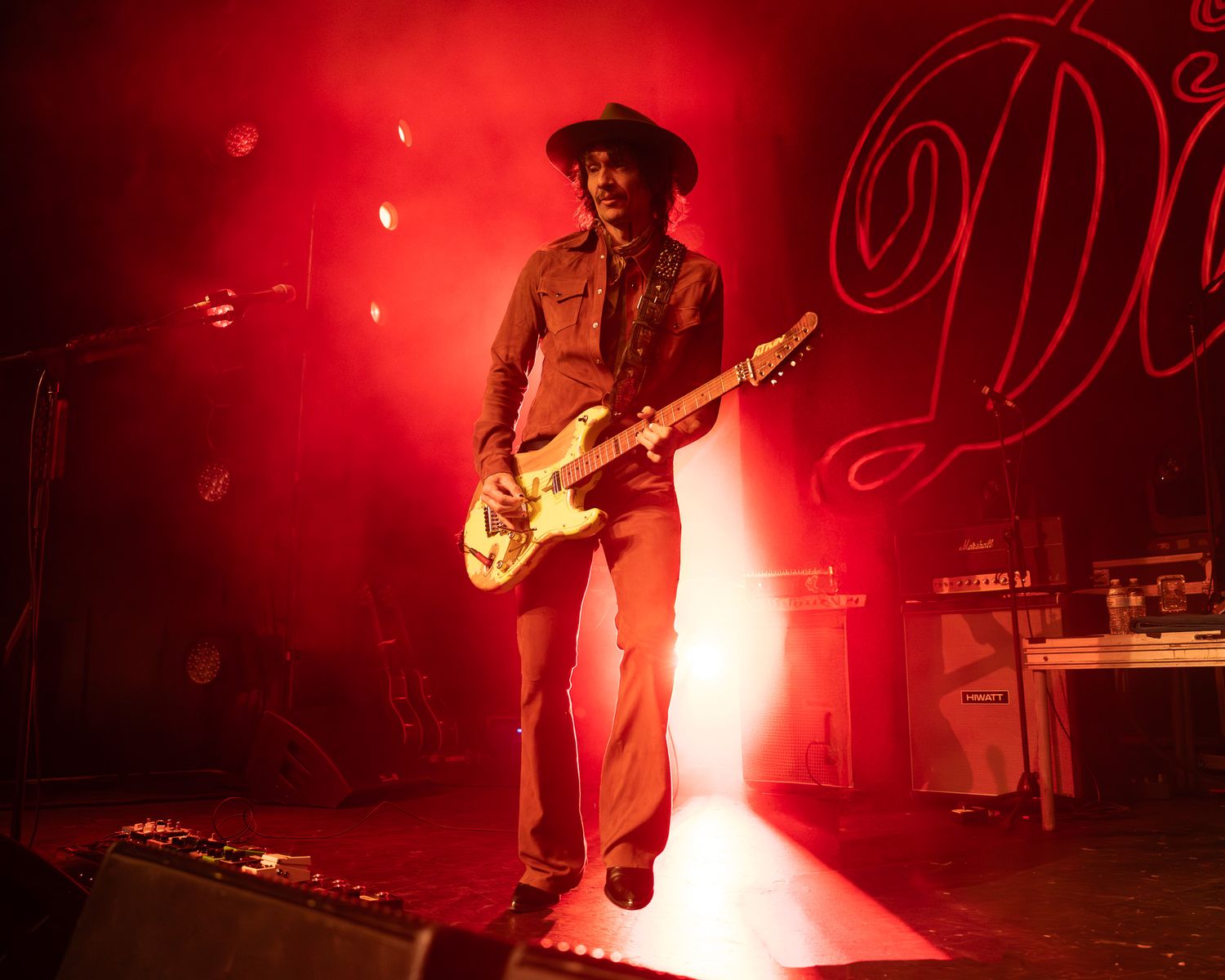 Justin Hawkins from The Darkness performing under red stage lighting at Emo's Austin in Austin, Texas.