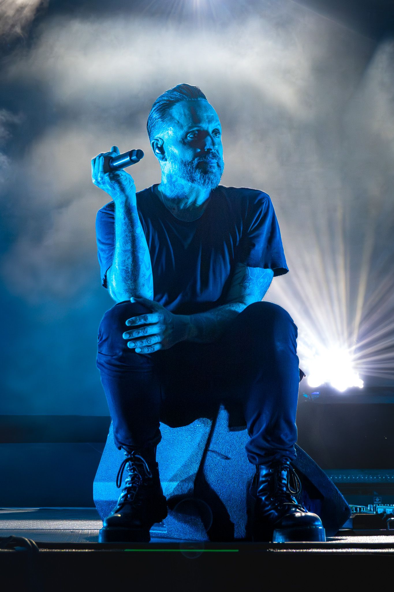 Justin Furstenfeld of Blue October performing under dramatic blue stage lighting at Moody Amphitheater in Austin, Texas.