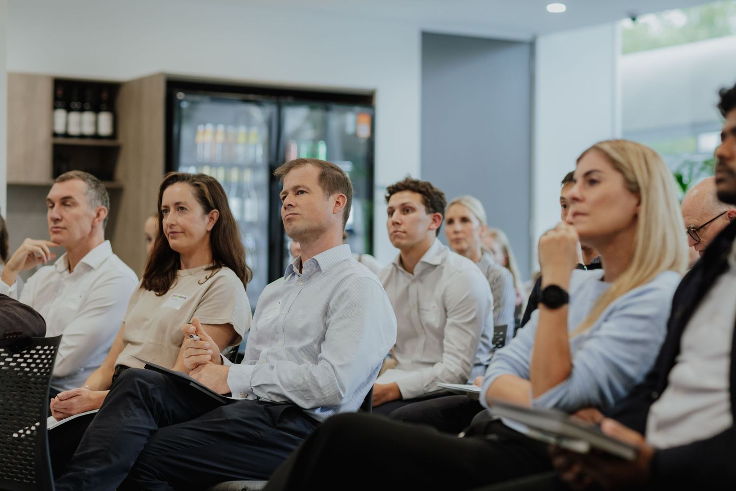 Engaged corporate audience seated and listening attentively during a professional business seminar.