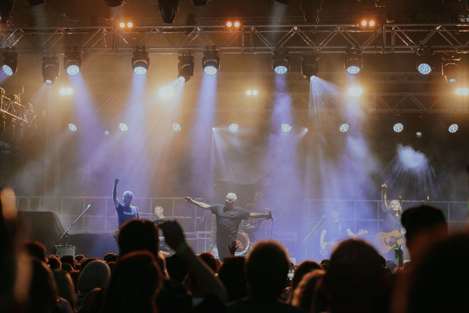 Band performing on stage with dramatic blue fog and bright spotlights at a live music concert.