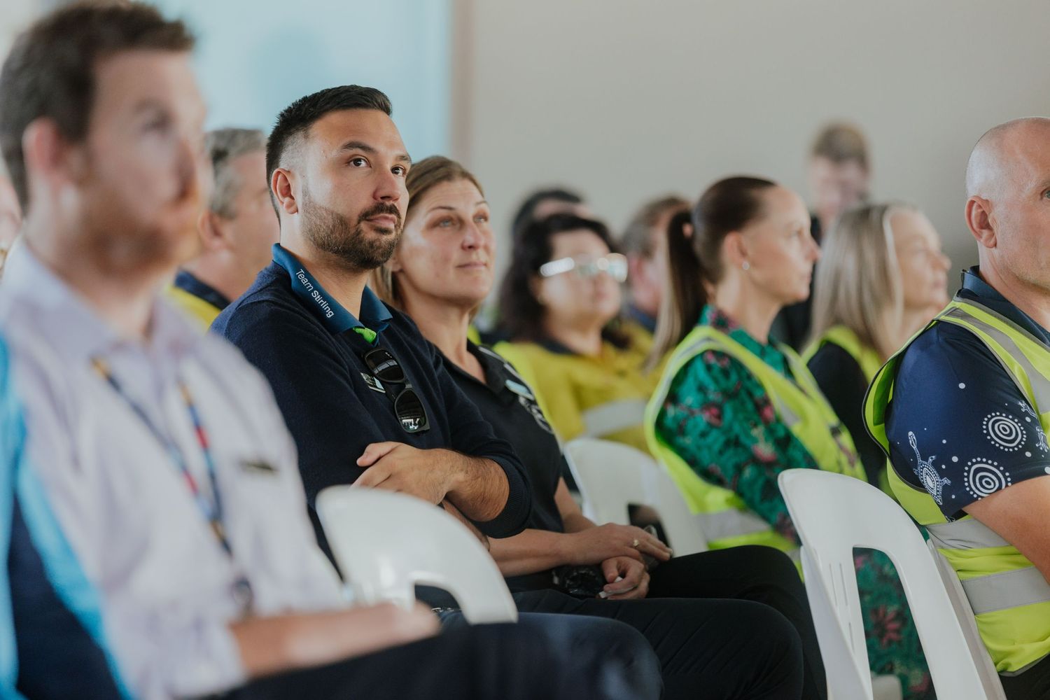 Diverse group of employees sitting attentively at a corporate workplace presentation or seminar.