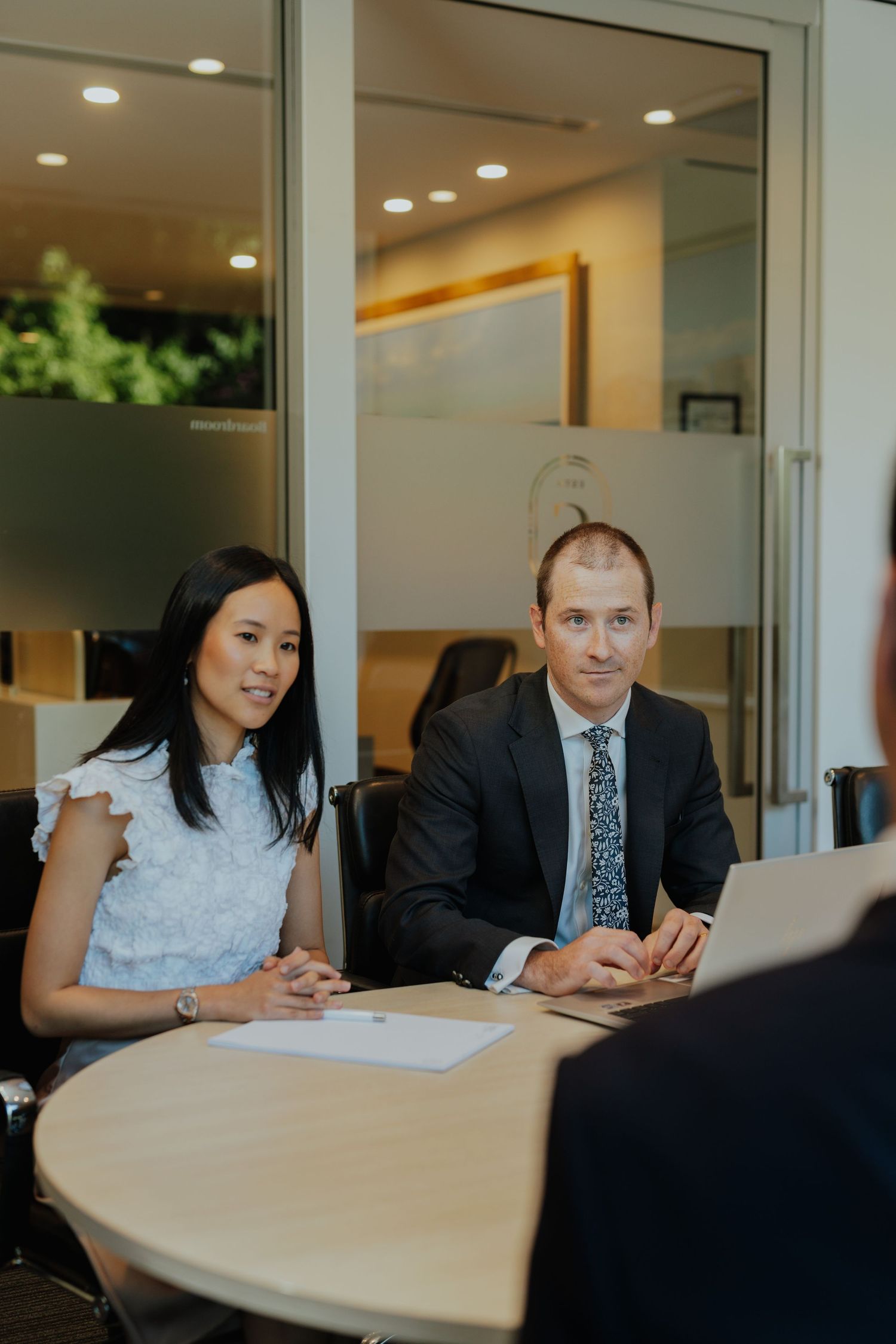 Business colleagues in formal attire engaged in professional meeting at conference table.