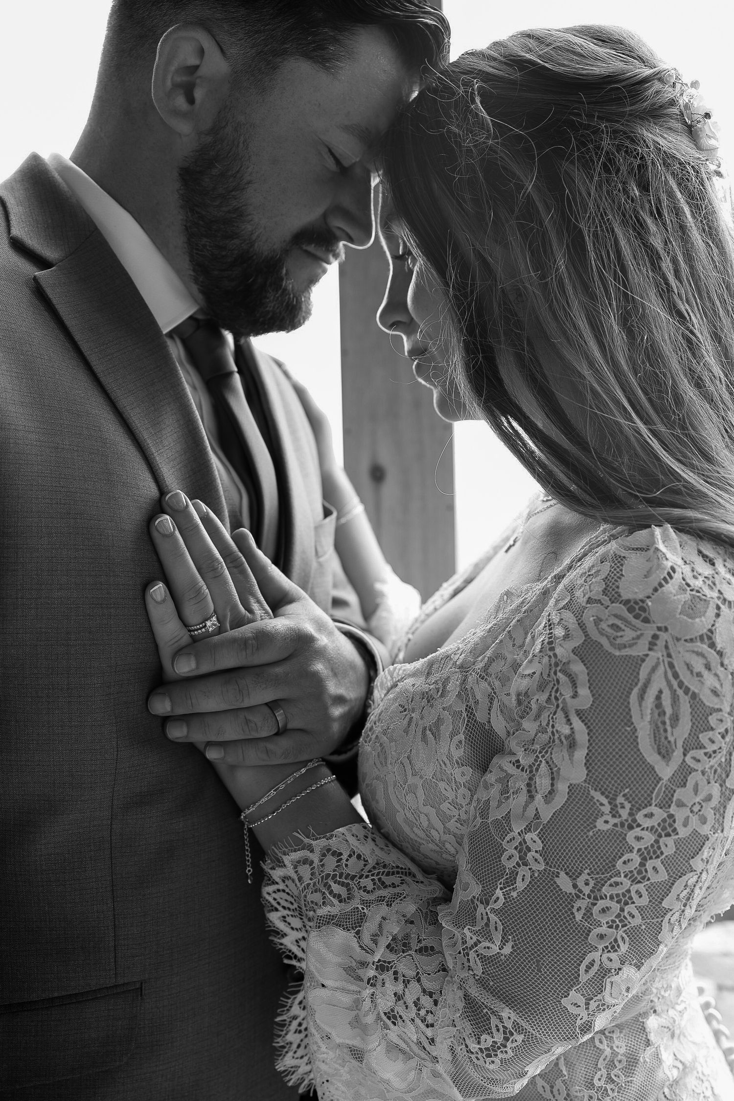 Black and white romantic wedding portrait of bride and groom touching foreheads tenderly.