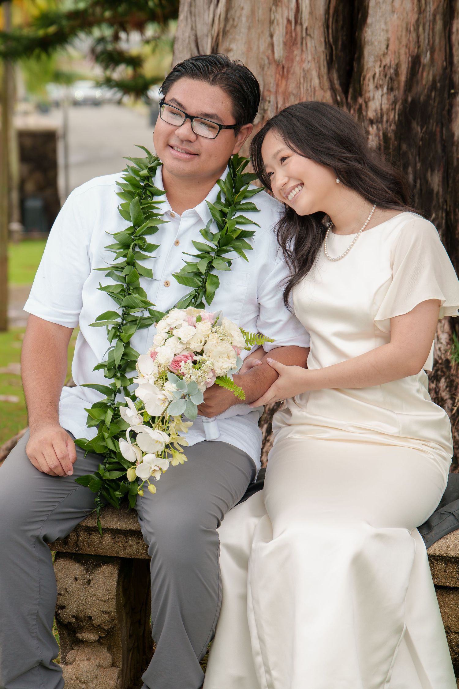 Newlywed couple seated together after their intimate Hawaiʻi wedding ceremony