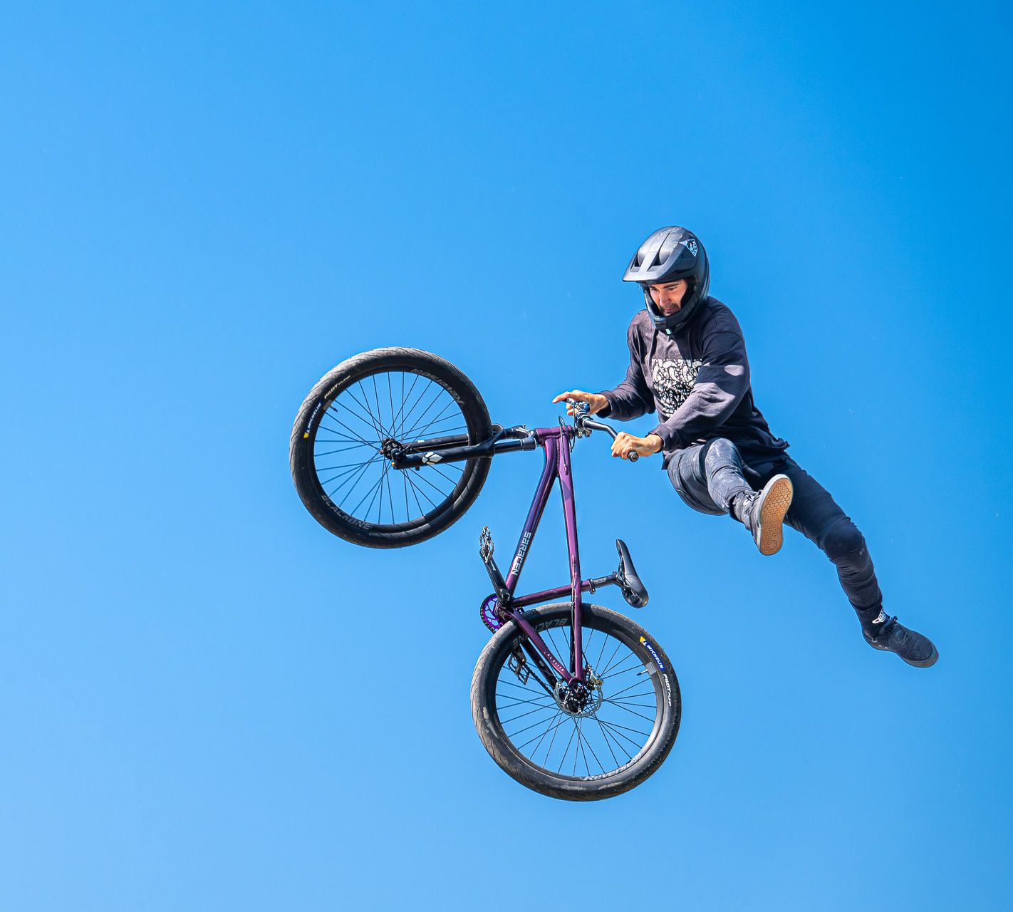 Pilote de dirt bike en figure aérienne lors de l'Outdoor Mix Festival d'Embrun, Hautes-Alpes, photographié par Yannick Eyraud