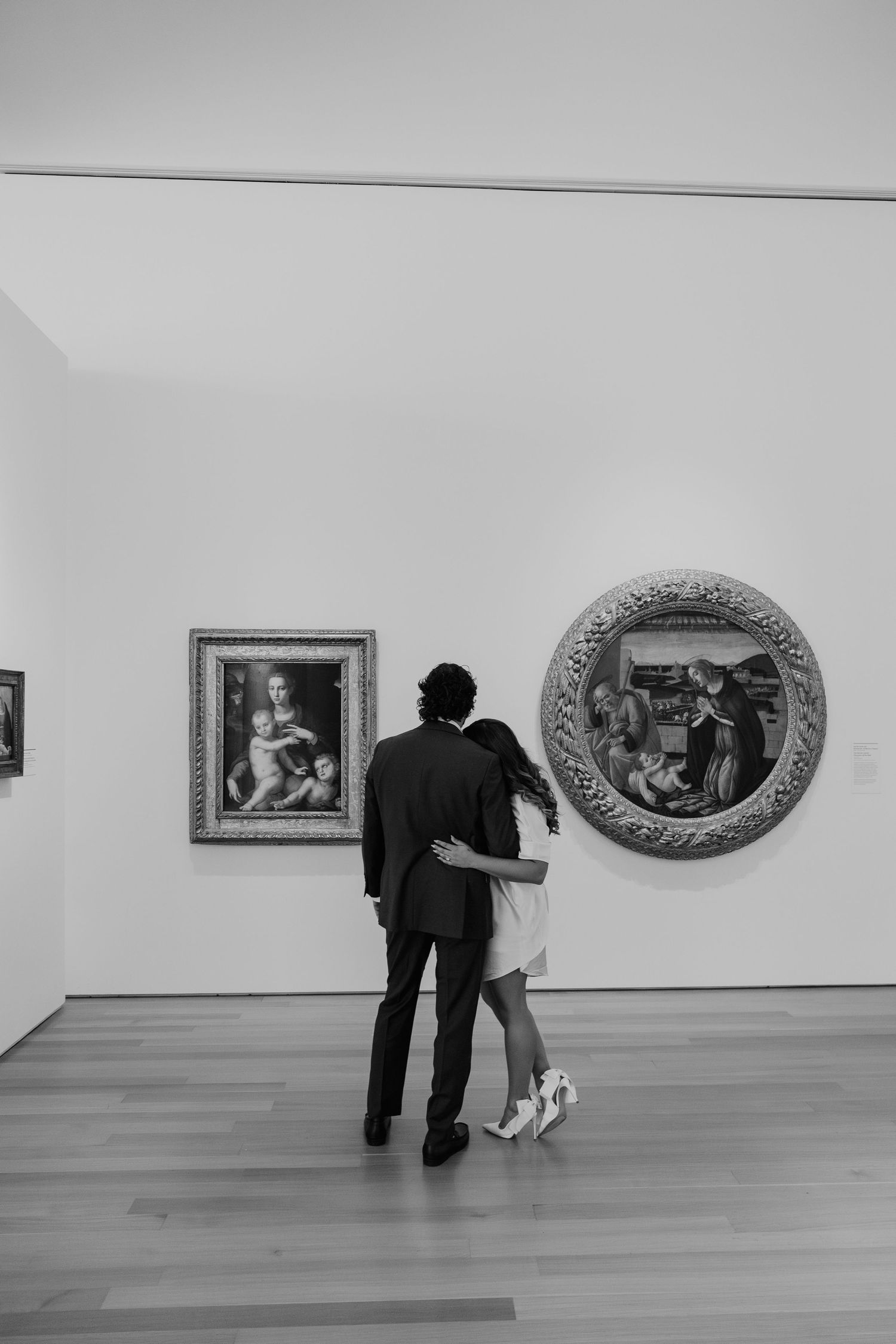 A couple stands in an art gallery, admiring the paintings and sculptures on display.