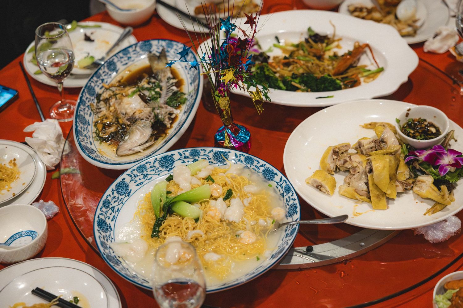 Traditional Chinese wedding banquet spread featuring steamed fish, congee, and assorted dishes on a round red table.