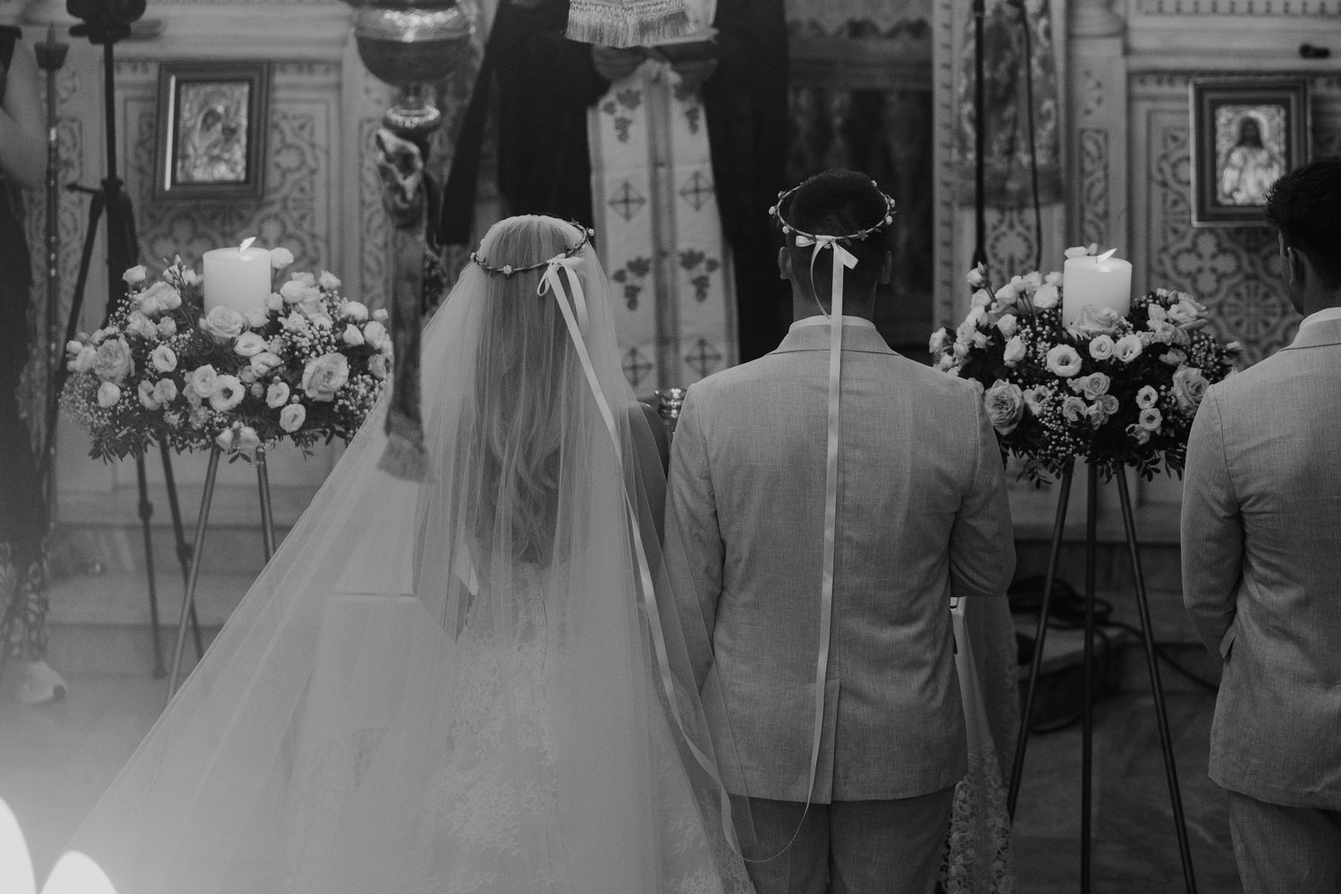 Black and white photo of a bride and groom standing at the altar during a traditional church wedding ceremony.