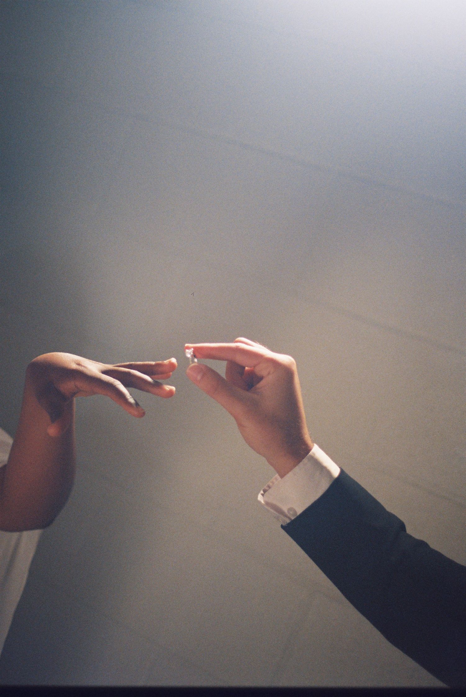A groom placing a wedding ring on a bride's finger during a romantic ceremony.