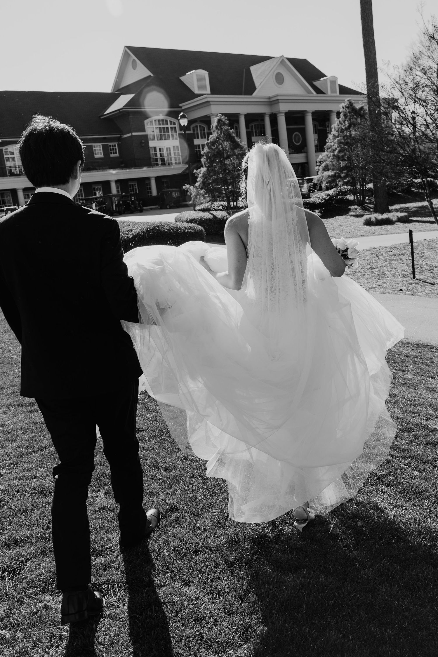 Black and white wedding photography sequence shows a bride's dress flowing gracefully in the wind as couple walks outdoors.