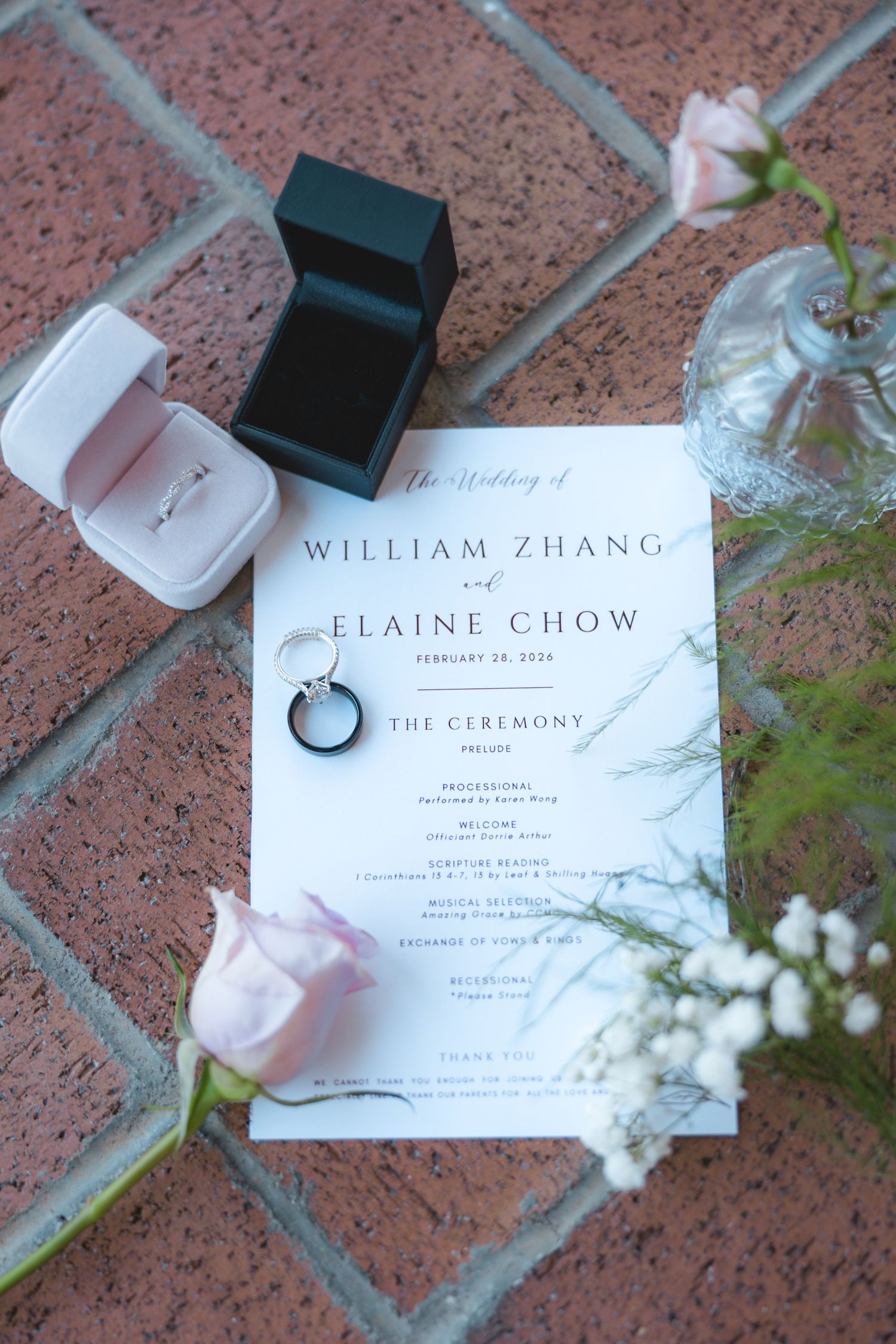 Wedding program for William Zhang and Elaine Chow on February 28 2026 with rings and pink roses on brick surface.