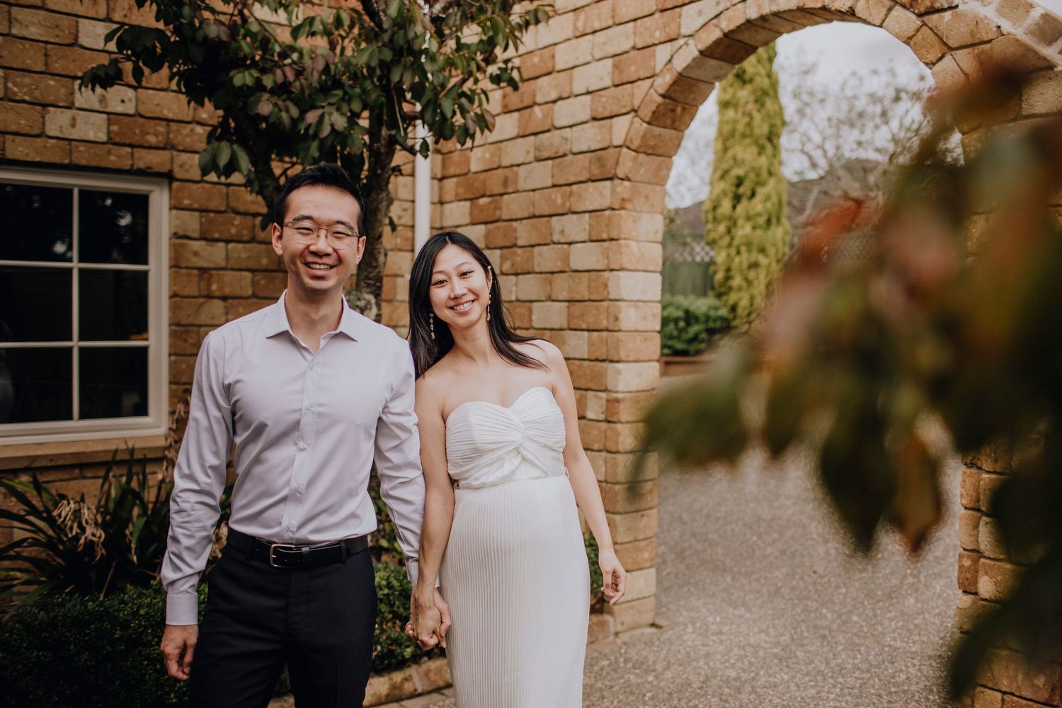 Newlyweds walking through Cornwall Park after their wedding