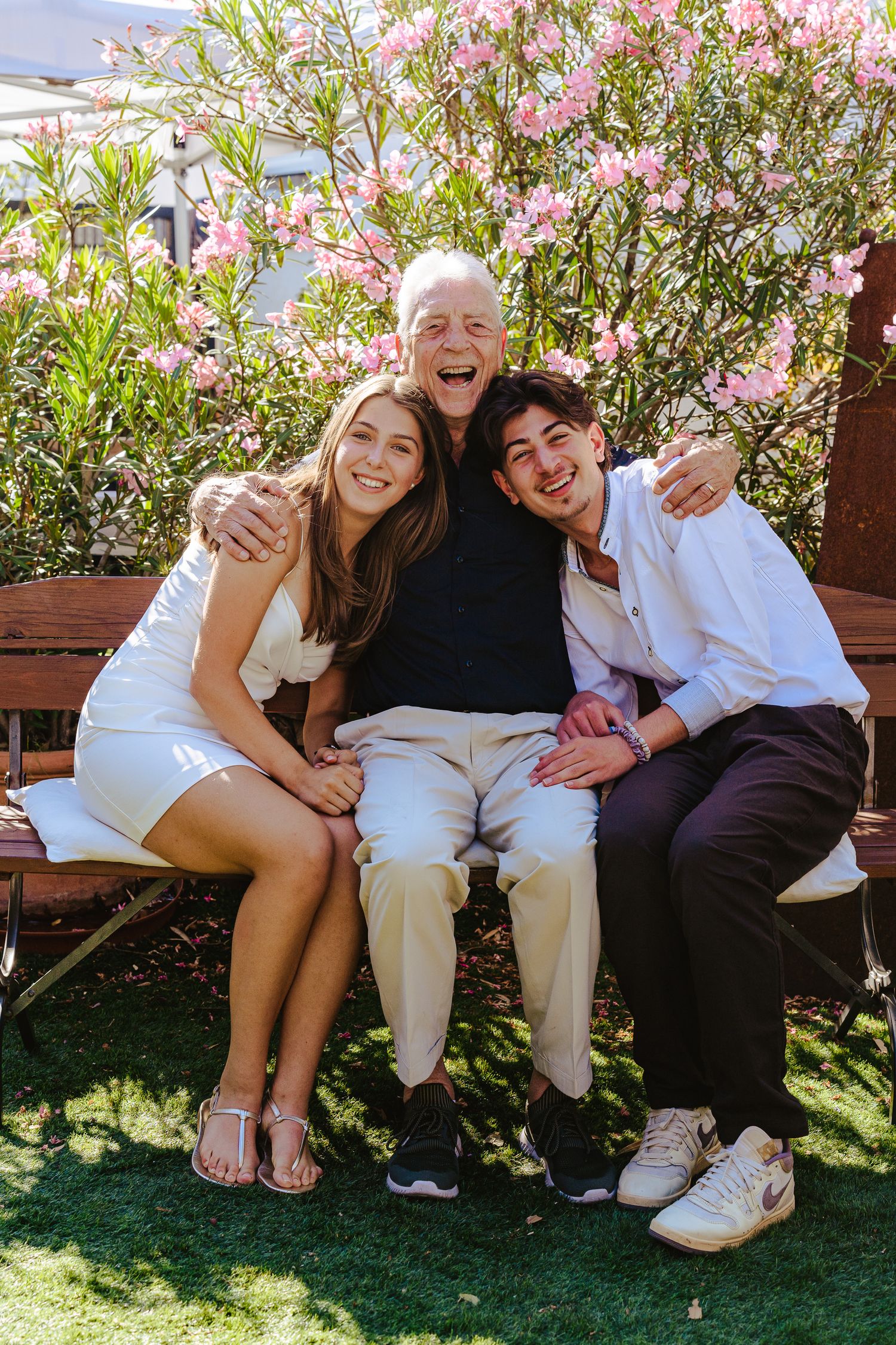 Joyful family portrait of a grandfather with his grandchildren outdoors, capturing genuine laughter, connection and togetherness.