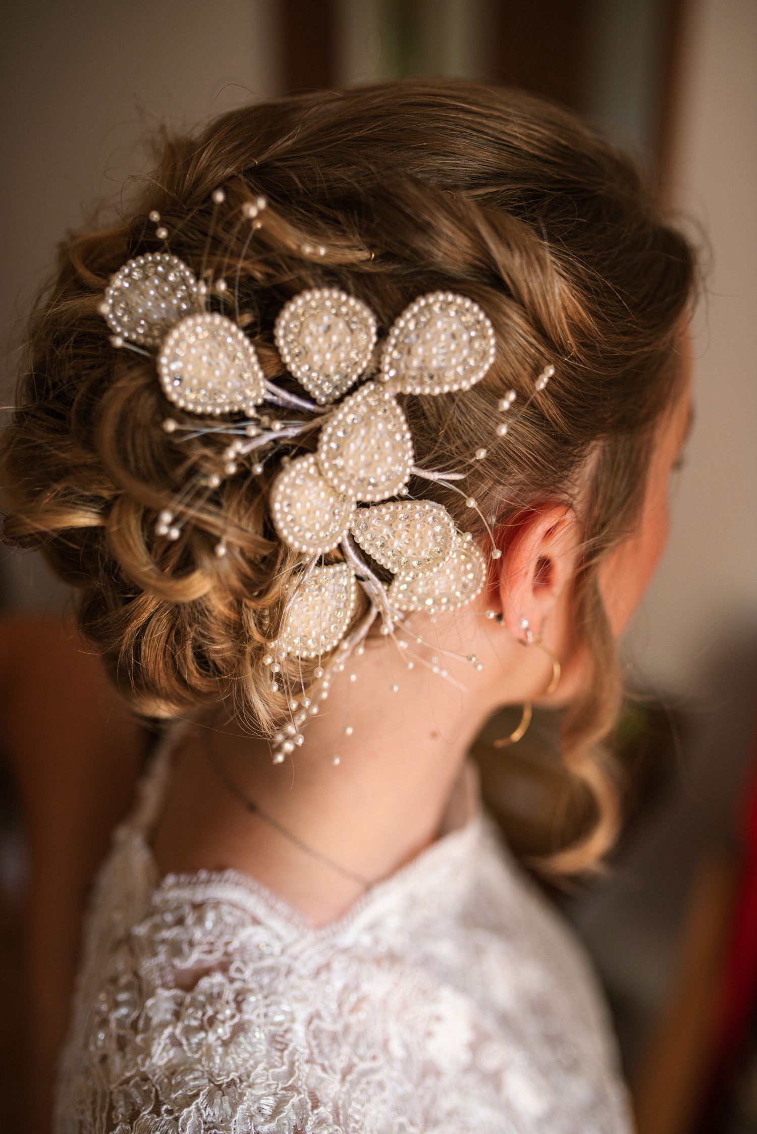 Elegant bridal updo adorned with pearl and crystal floral hair accessories.